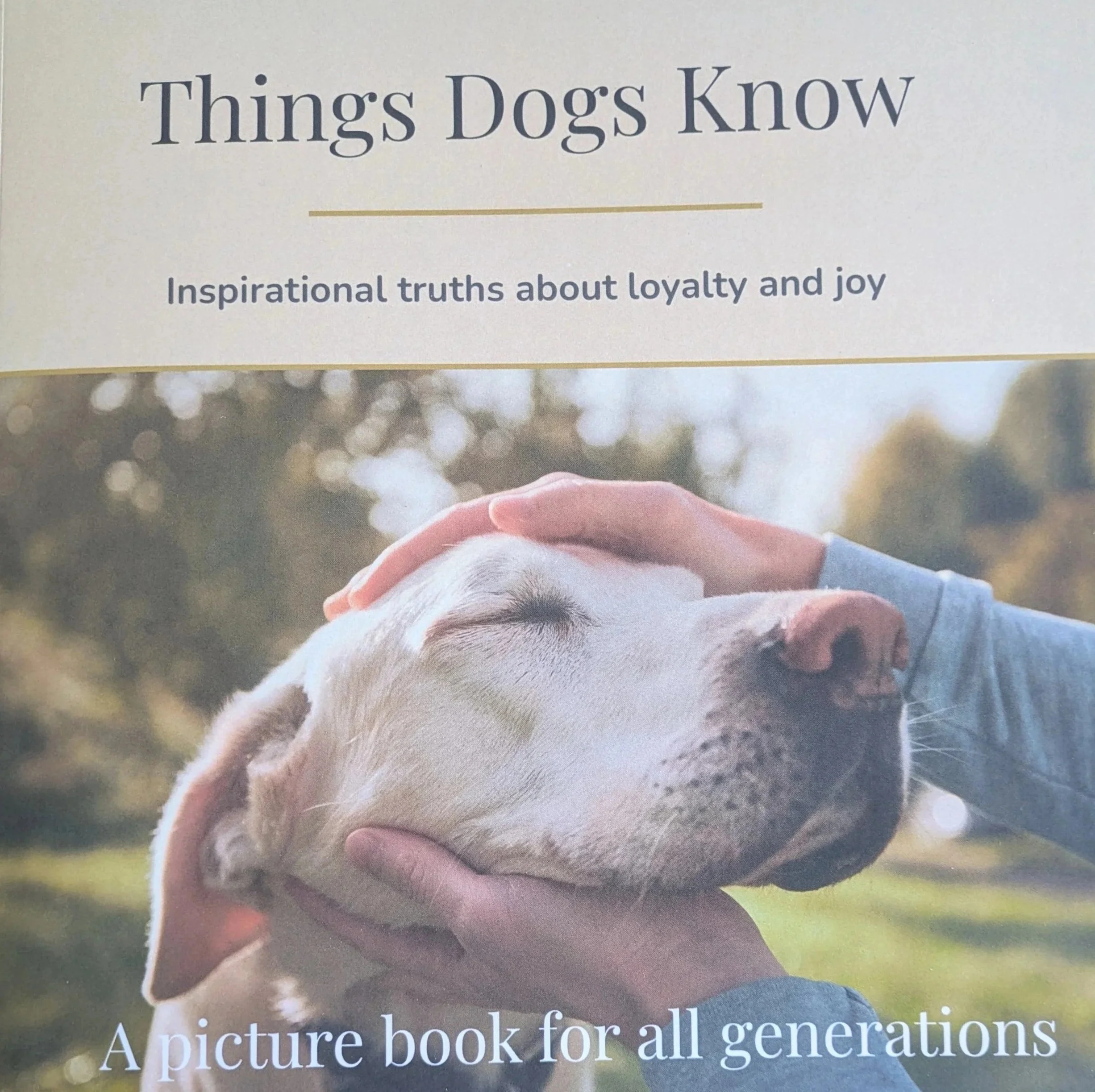 Book cover titled 'Things Dogs Know' with a photograph of a person gently petting a sleeping Labrador retriever outdoors.