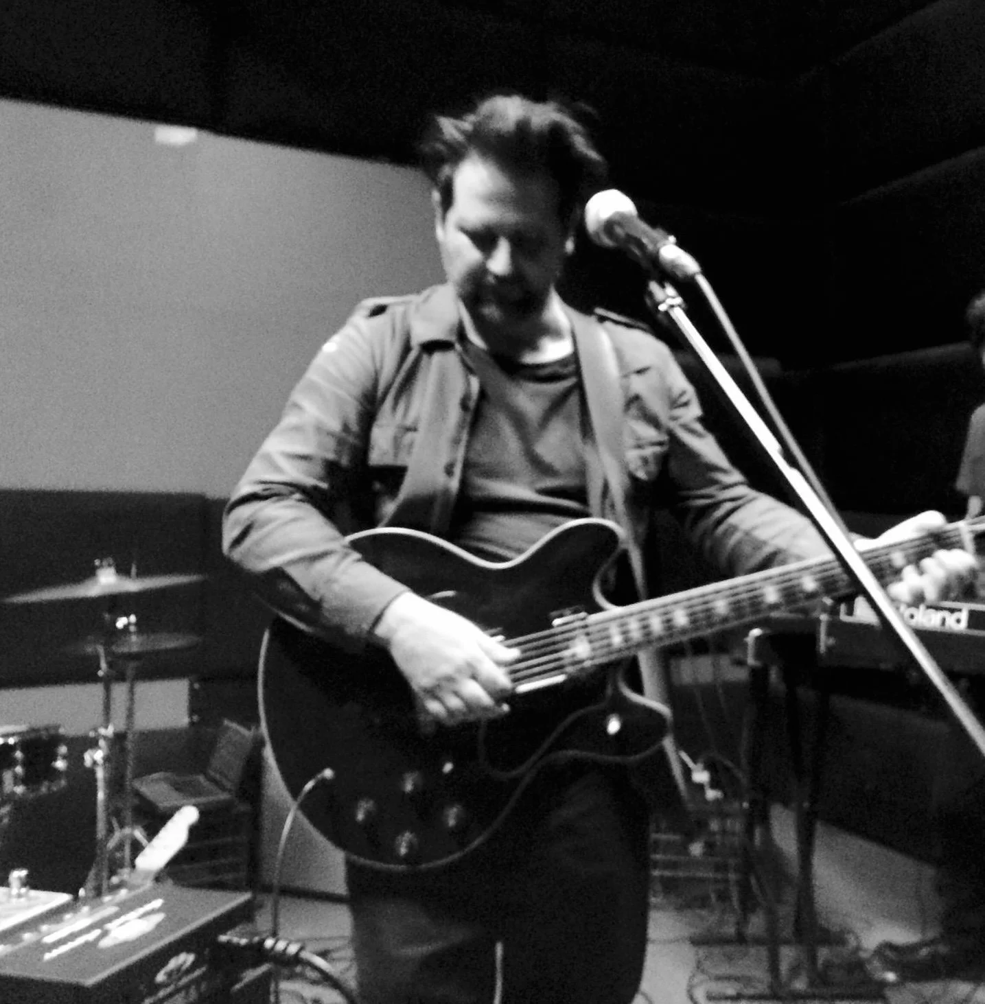 A musician playing an electric guitar in a recording studio.