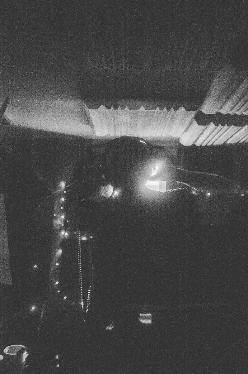 Dark interior of a vehicle with dashboard lights and a partially visible steering wheel, taken at night.