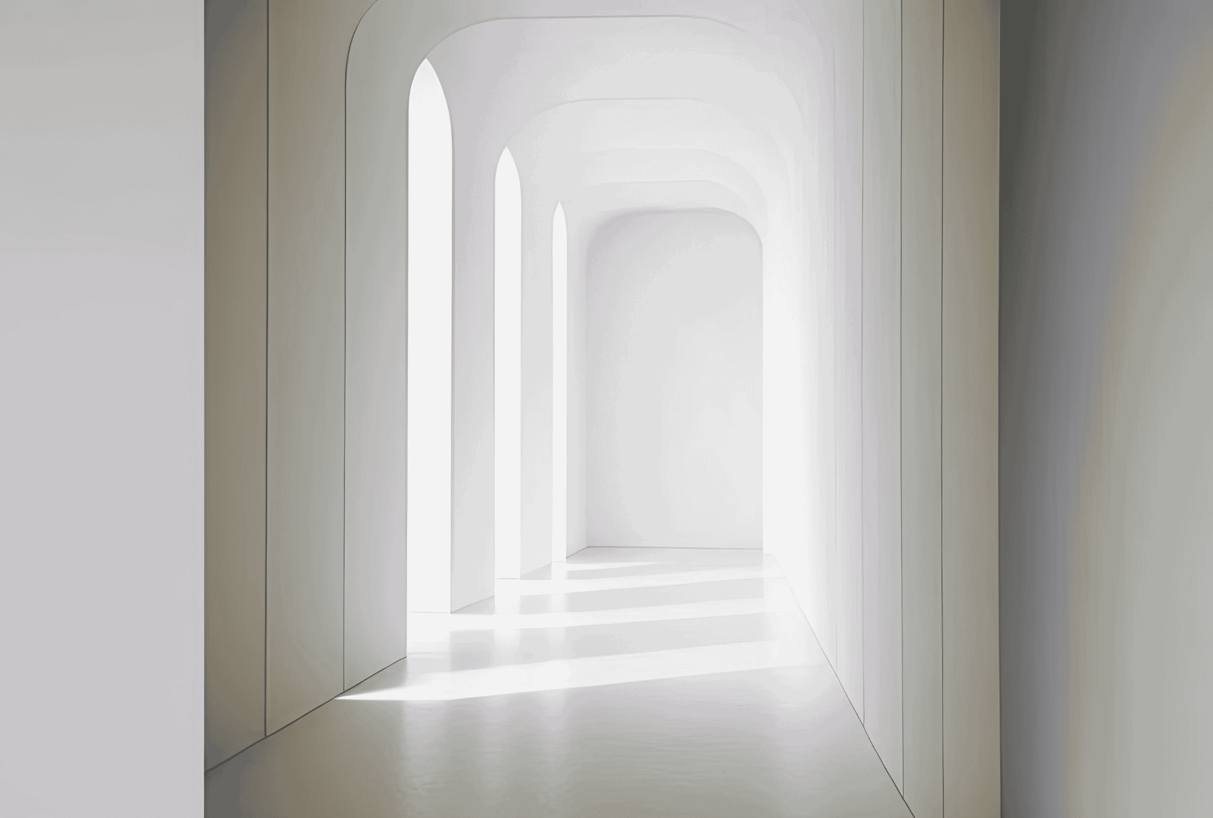 白い壁とアーチ型の窓から自然光が差し込むシンプルな廊下