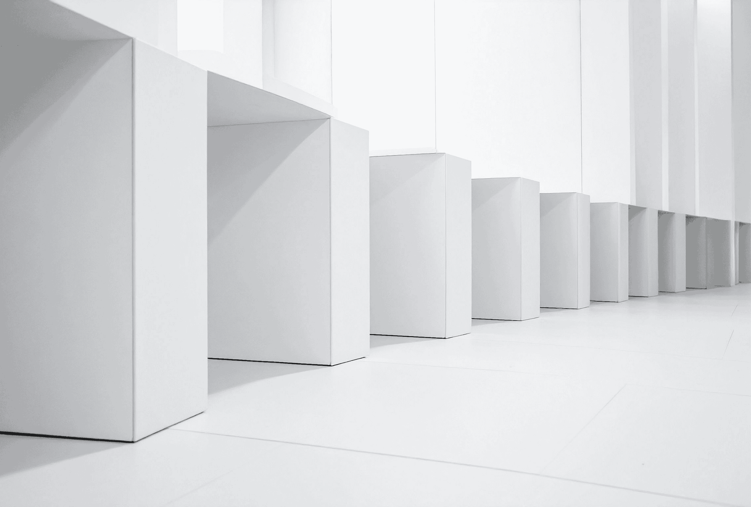 白い棚が連続して並んだシンプルな室内空間