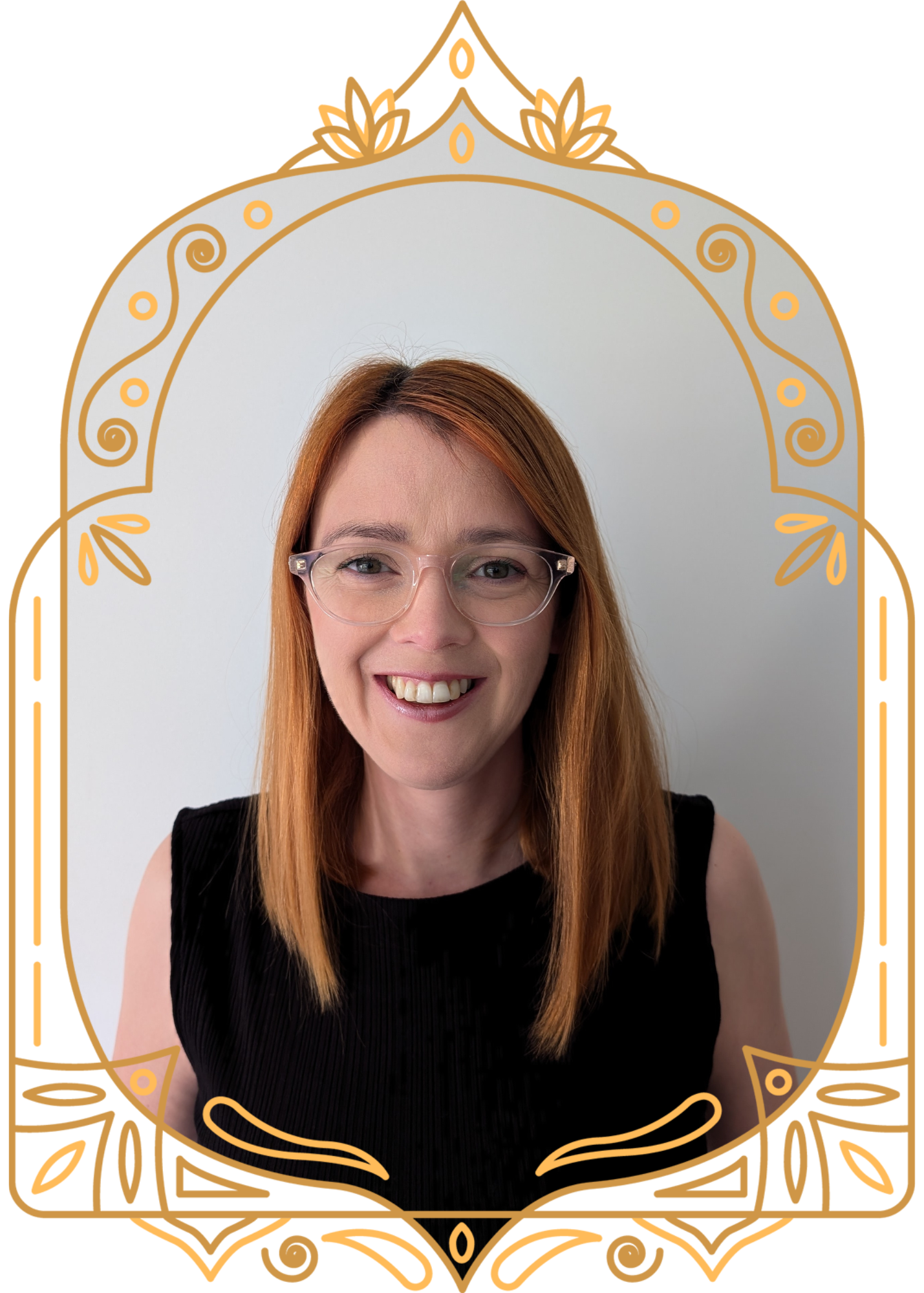 A woman with red hair, glasses, and wearing a black top smiling at the camera.