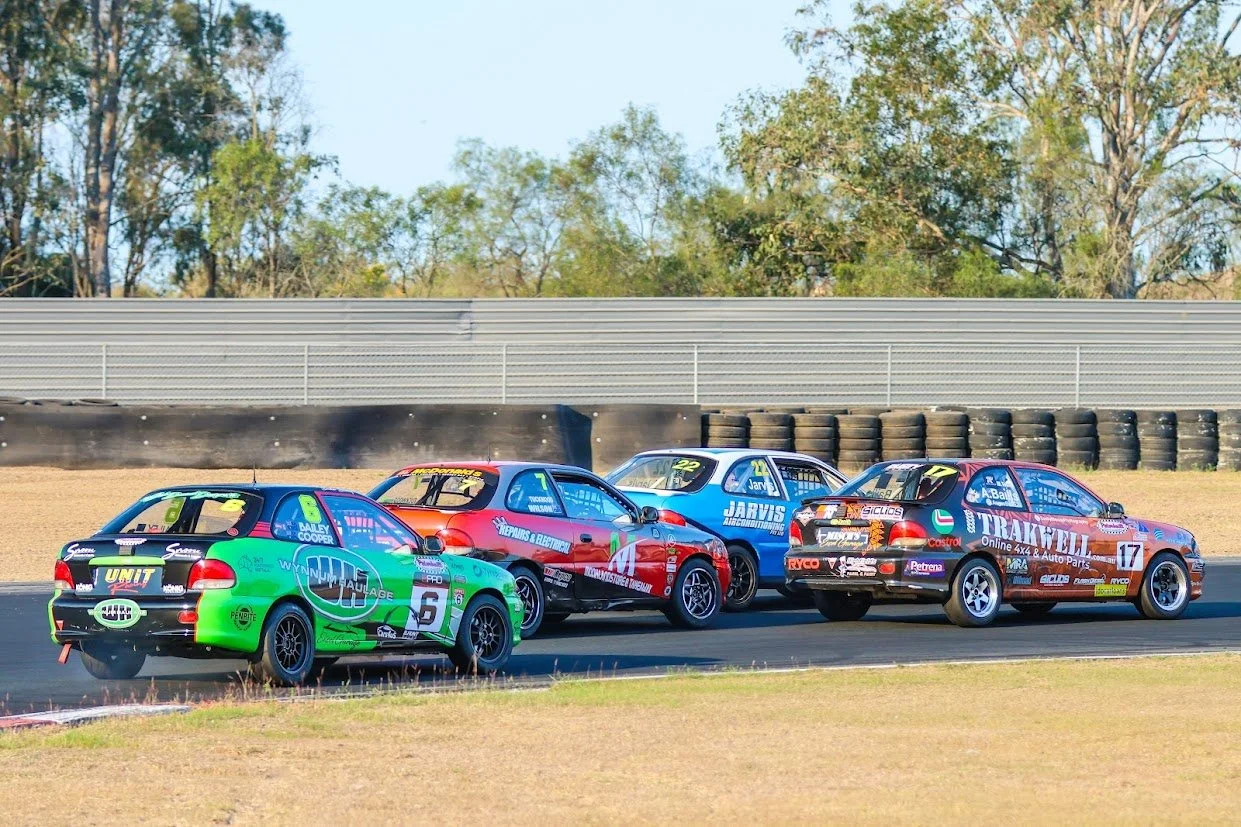 Four race cars on a track during a race.