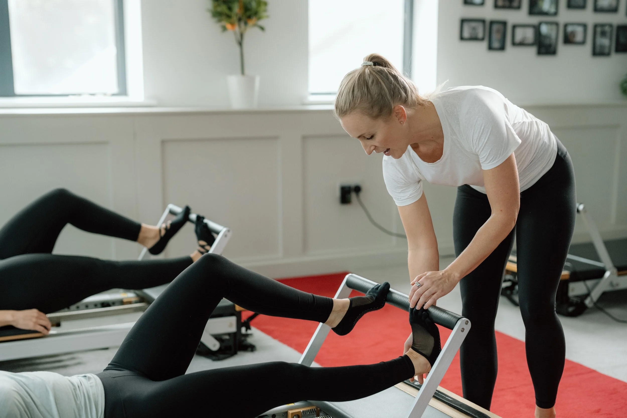 Client practising Reformer Pilates with expert instructor guidance