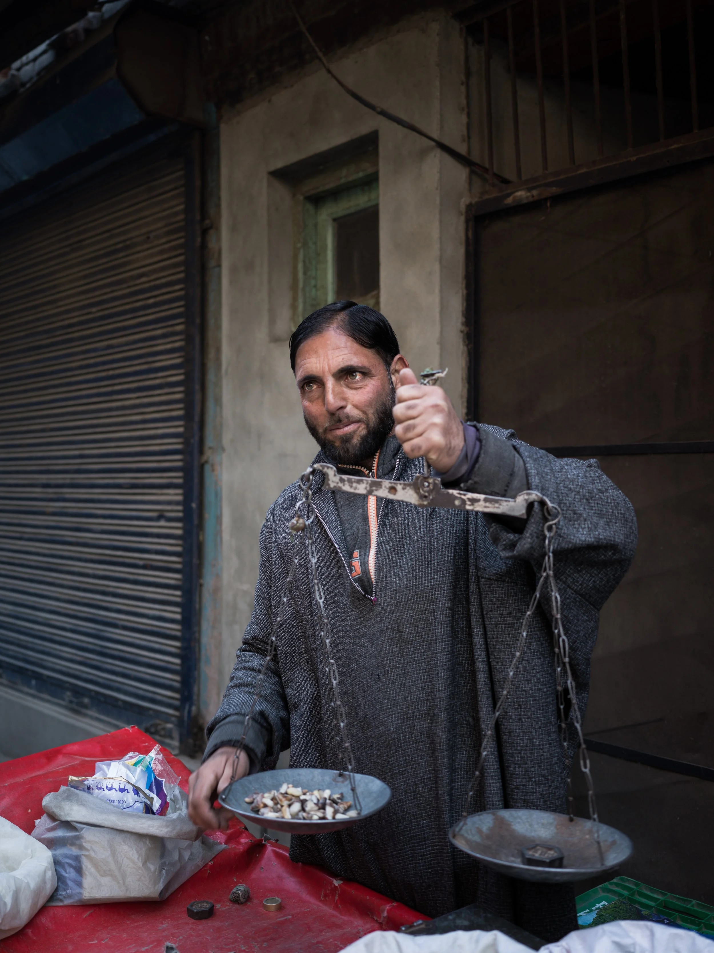 A Kashmiri man using an antique balance weighing scale, found in Srinagar, Kashmir, India