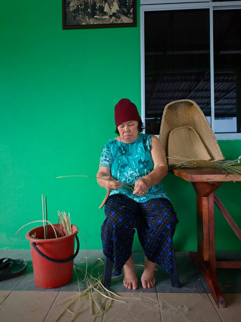 Bidayuh woman weaving with sago leaves in Kuching, Sarawak