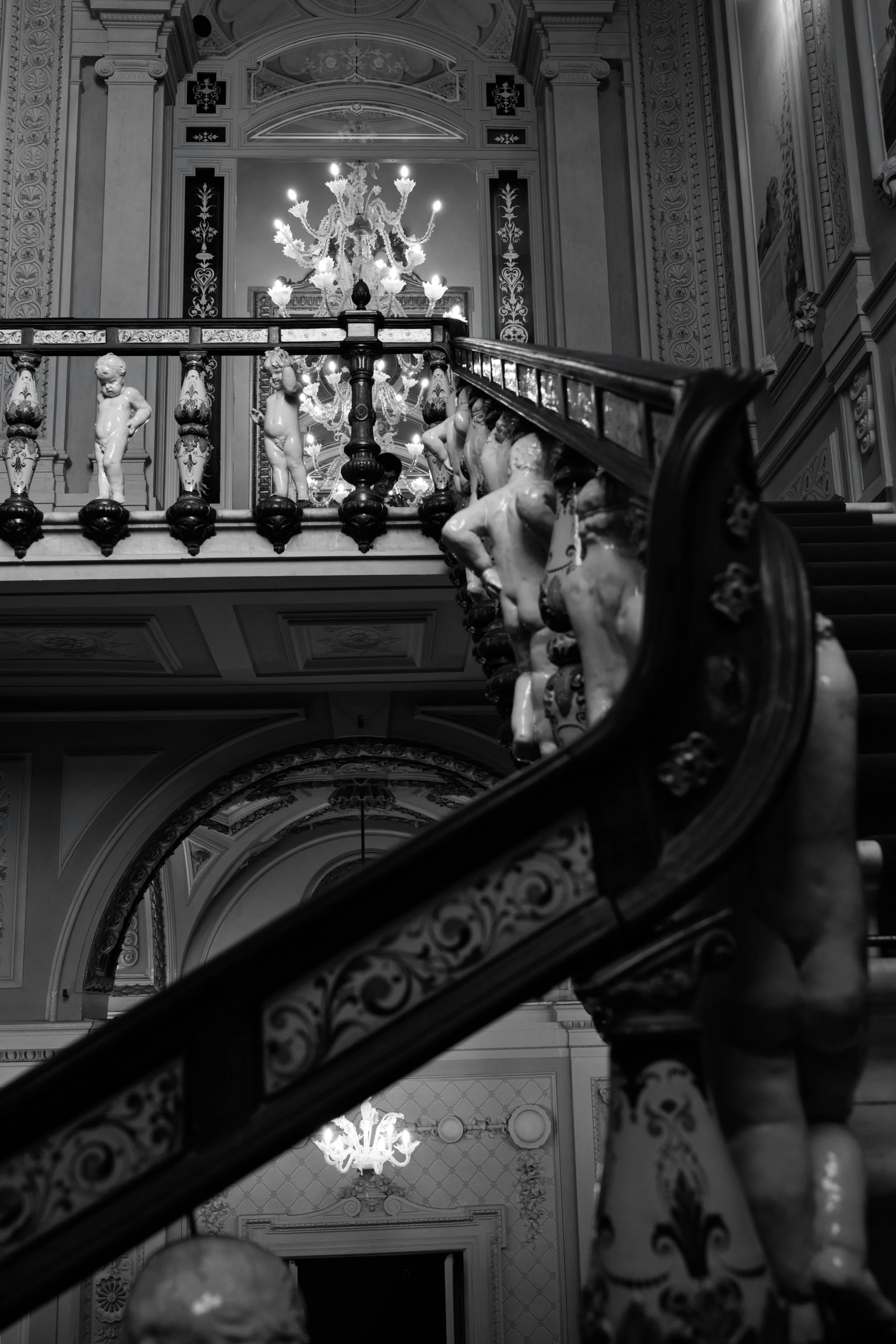 Dettaglio architettonico in bianco e nero di una villa storica toscana con scalinata monumentale e gestione della luce naturale da una grande finestra decorata