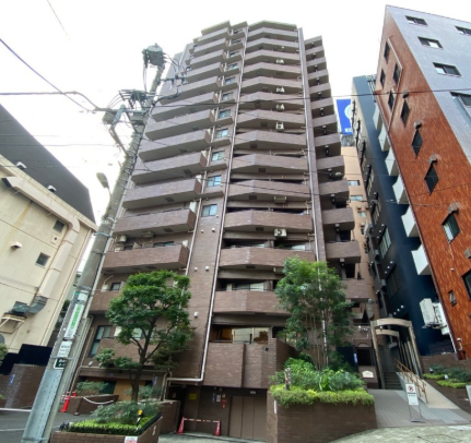 高層のマンションと周囲の建物、樹木、電柱