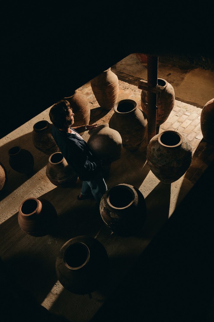 Grote antieke aardewerken potten in karaktervolle ruimte met natuurlijk licht.