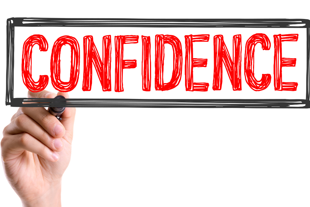 Hand writing “CONFIDENCE” in bold red letters inside a drawn box symbolizing personal growth, boundaries, and rebuilding self worth.