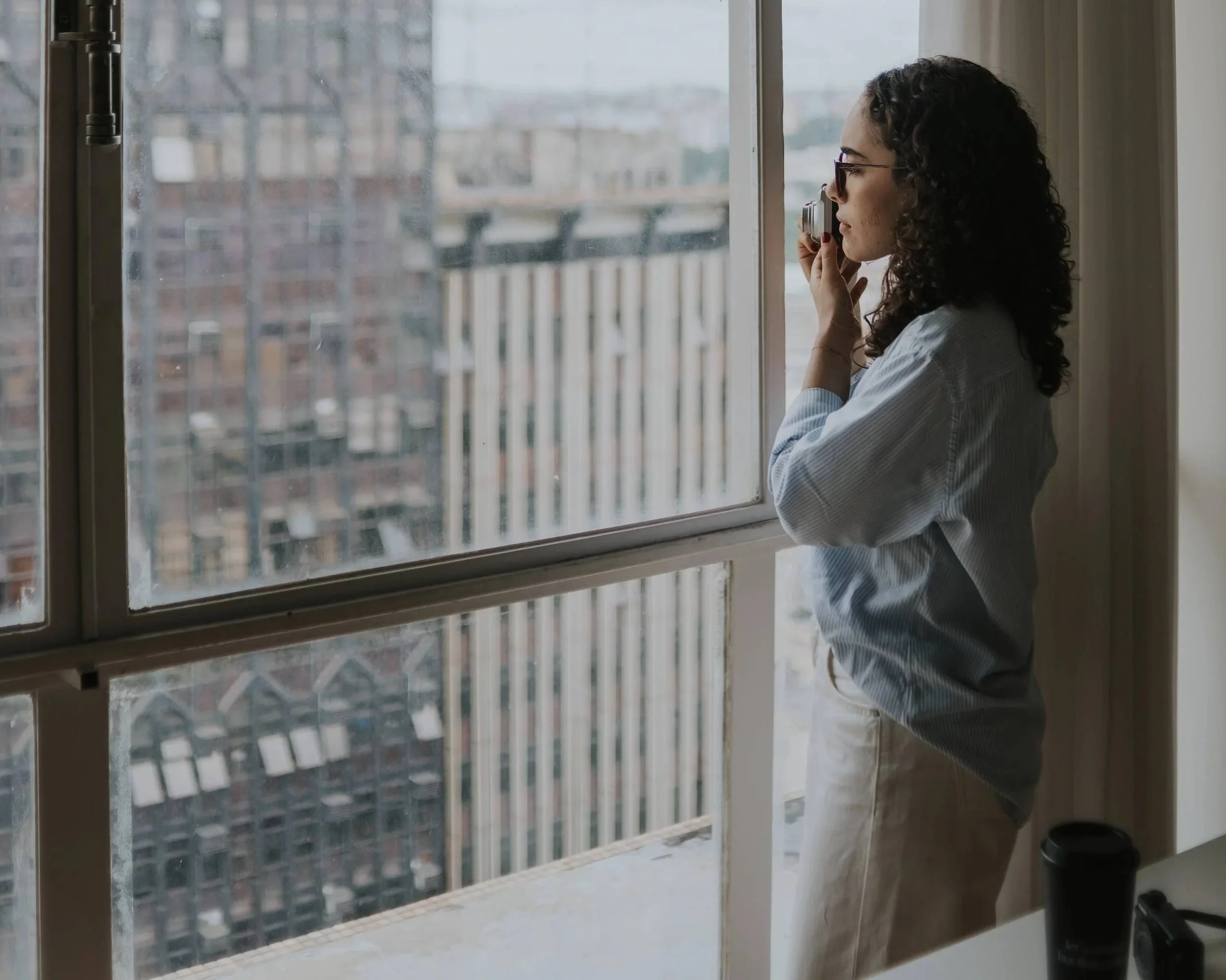 Woman overlooking a city skyline, representing high-functioning trauma, survival mode, emotional exhaustion, and healing after relational trauma.