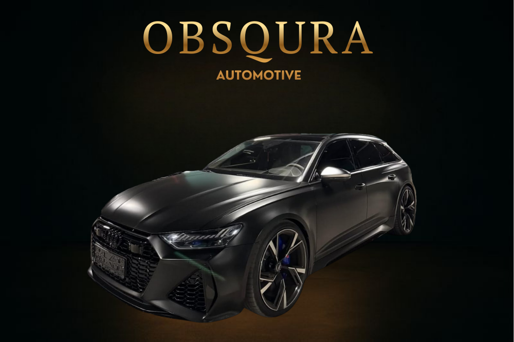 A black Audi station wagon in front of a black background with gold text that reads 'OBSCURA AUTOMOTIVE'