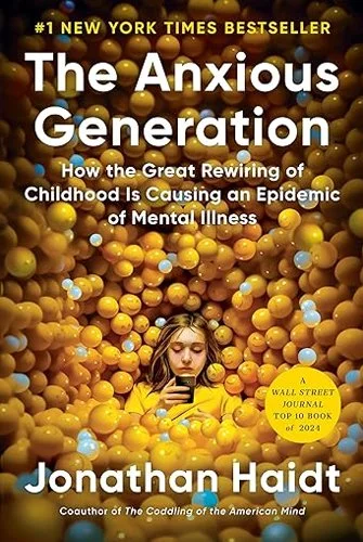 Book cover of 'The Anxious Generation' by Jonathan Haidt featuring a young girl submerged in yellow and orange balls, with the title and author text overlaid.