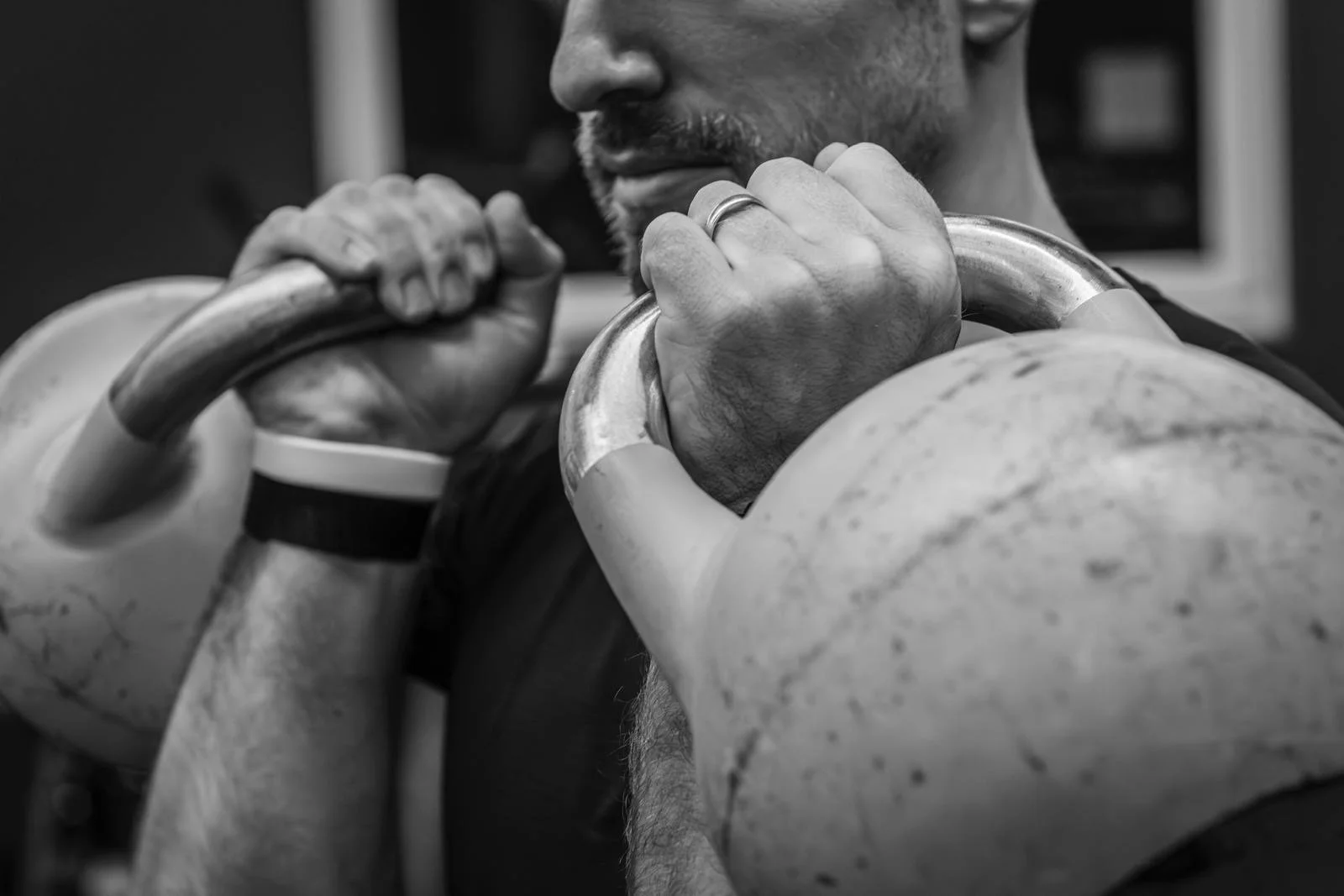 Ein Mann hebt mit beiden Händen Hanteln beim Krafttraining