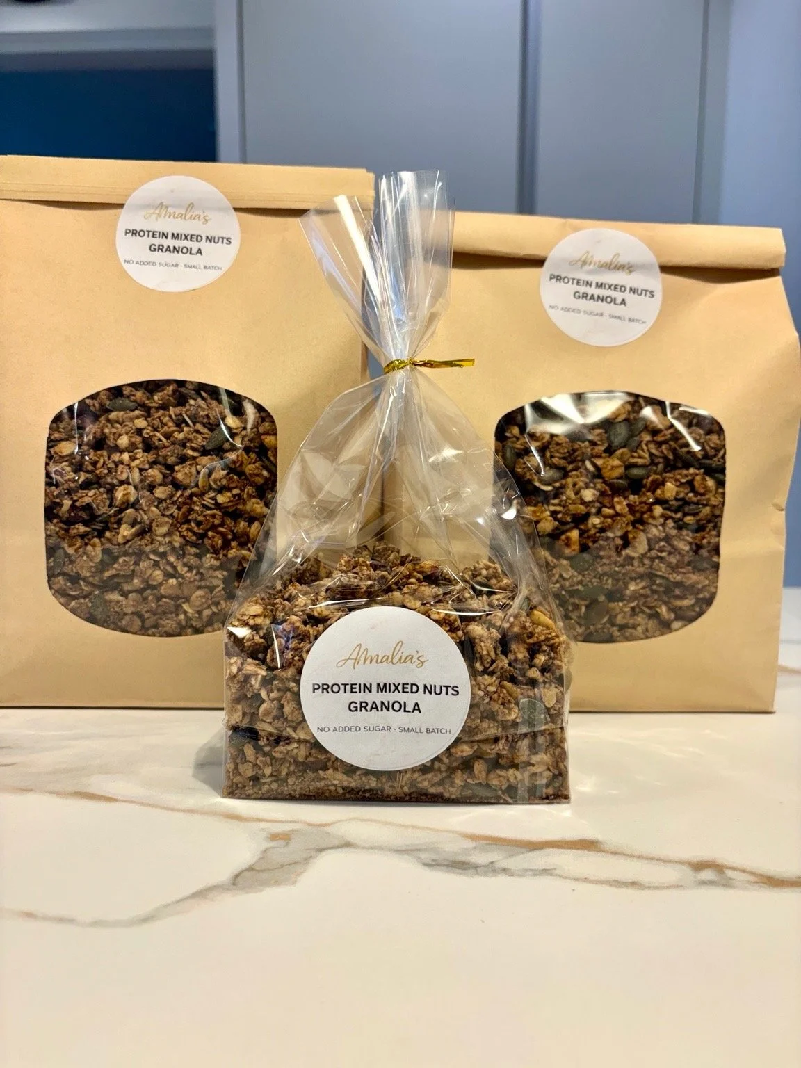 A landscape with snow-capped mountains in the background and rolling green hills in the foreground, featuring a modern building with wooden and stone elements.