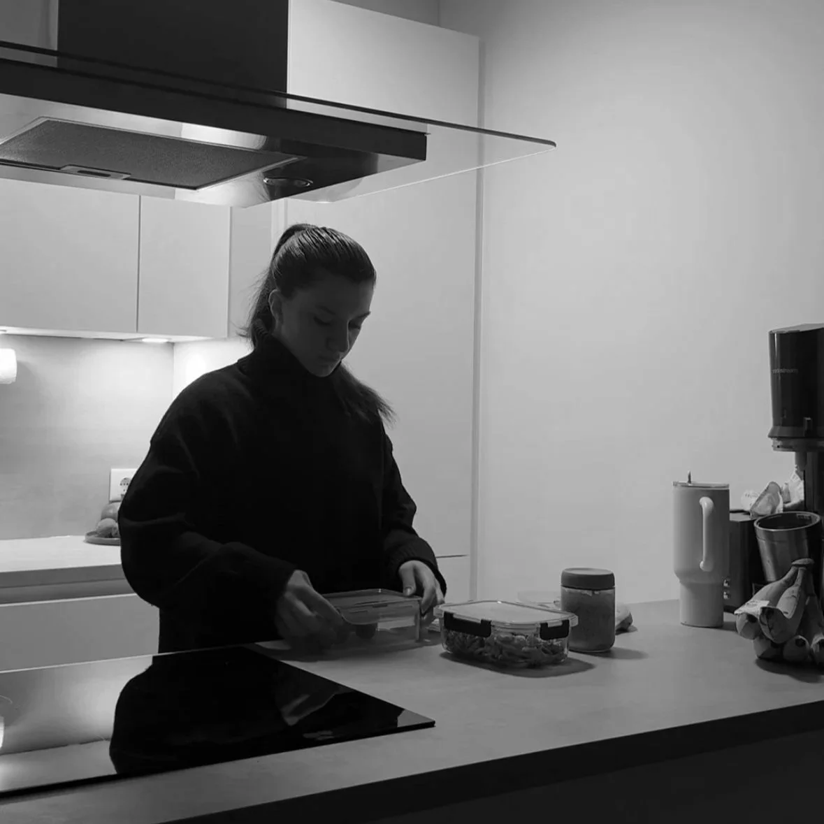 Eine junge Frau steht in einer modernen, minimalistischen Küche und bereitet Mahlzeiten vor. Ernährungswissenschaften und Ernährungsberatung und Fitness.