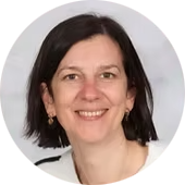 Portret van een vrouw met korte, darke haar en een witte blouse, glimlachend