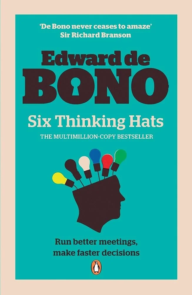 Book cover of 'Six Thinking Hats' by Edward de Bono, featuring a silhouette of a head with six colored light bulbs representing thinking hats.