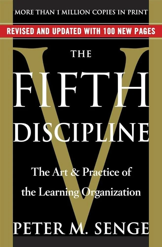 Cover of a book titled "The Fifth Discipline" by Peter M. Senge, featuring a large 'V' in the background, with text indicating it is a revised edition with 100 new pages and over one million copies sold.
