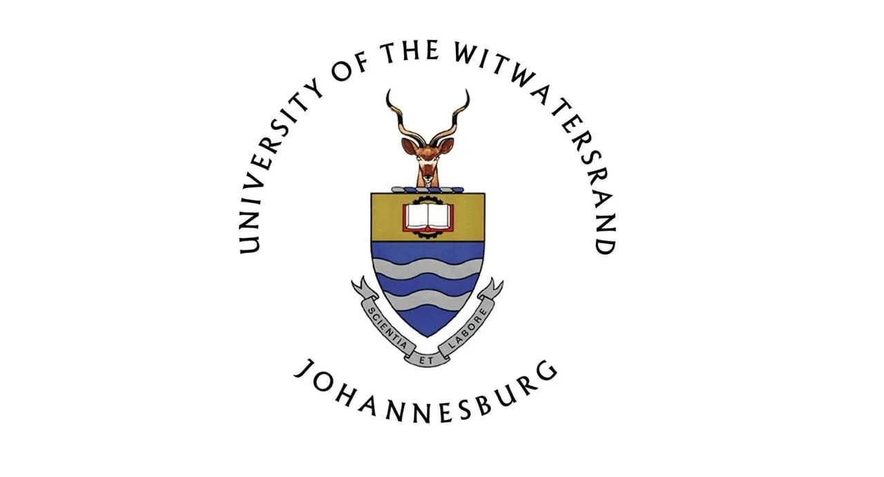 The emblem of the University of the Witwatersrand, Johannesburg, featuring a shield with a book and blue waves, a head of a kudu antelope, and a banner with Latin motto.