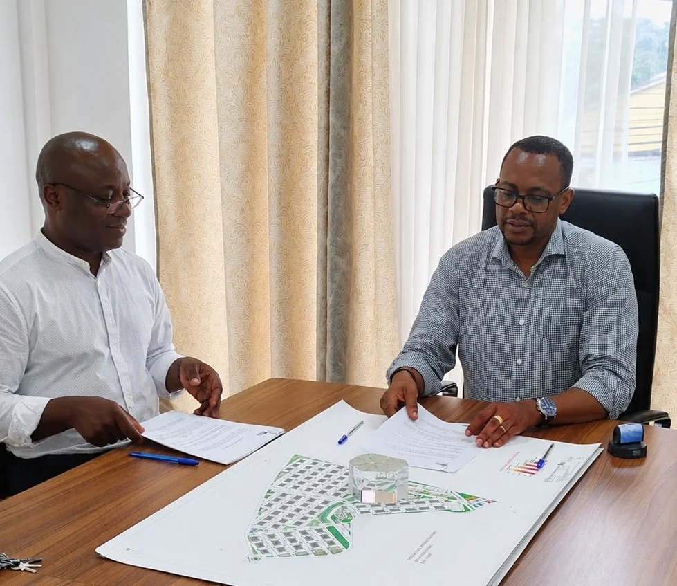 Dois homens sentados em uma mesa de escritório analisando documentos e um mapa de um projeto de construção, com cortinas ao fundo.