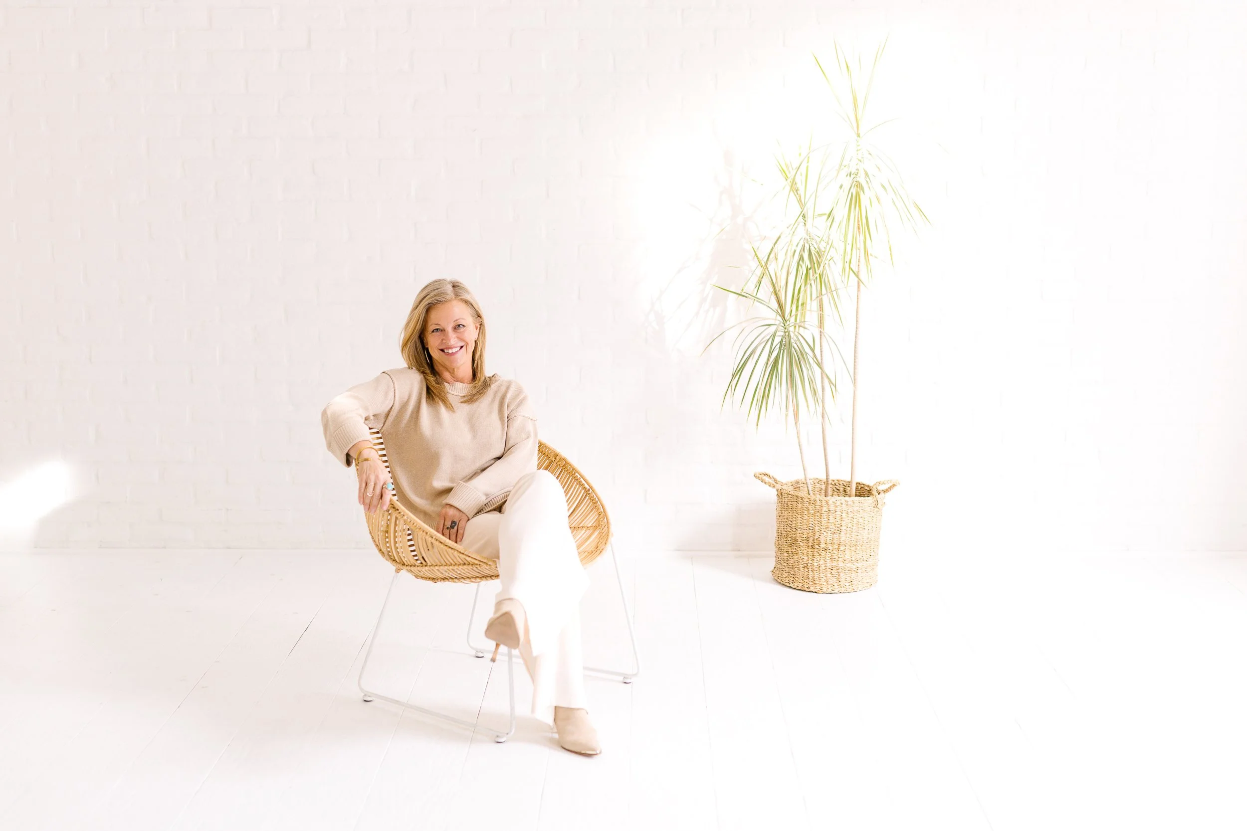 Female keynote speaker smiling in a chair during a branding photo session at a studio in downtown boise.