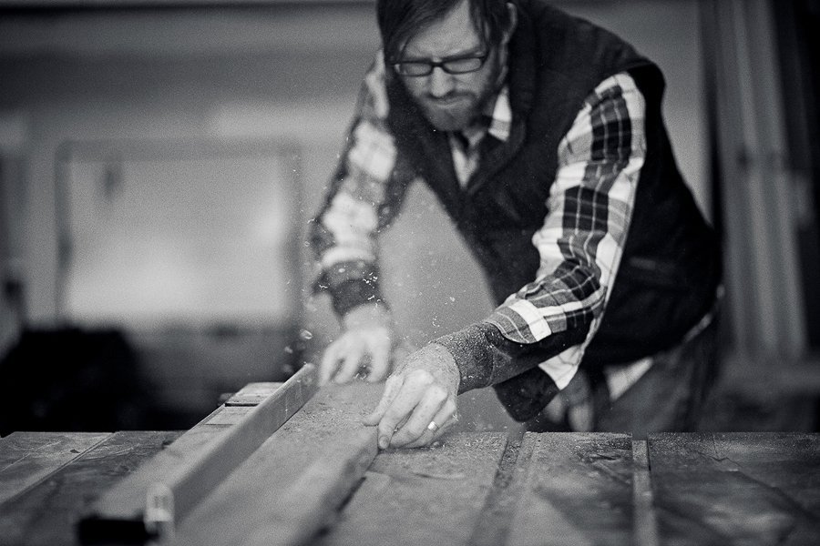 Man cutting a board on a table saw during a commercial photoshoot in Boise.
