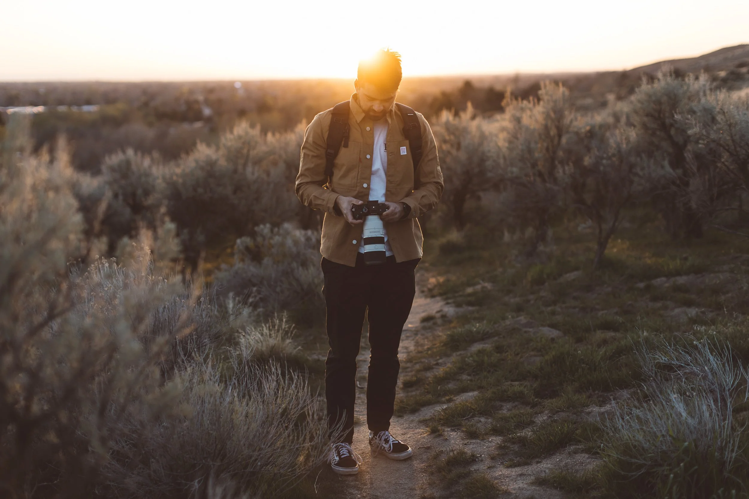 Creative entrepreneur looking at camera during a boise branding photo session at golden hour in the Boise Foothills.