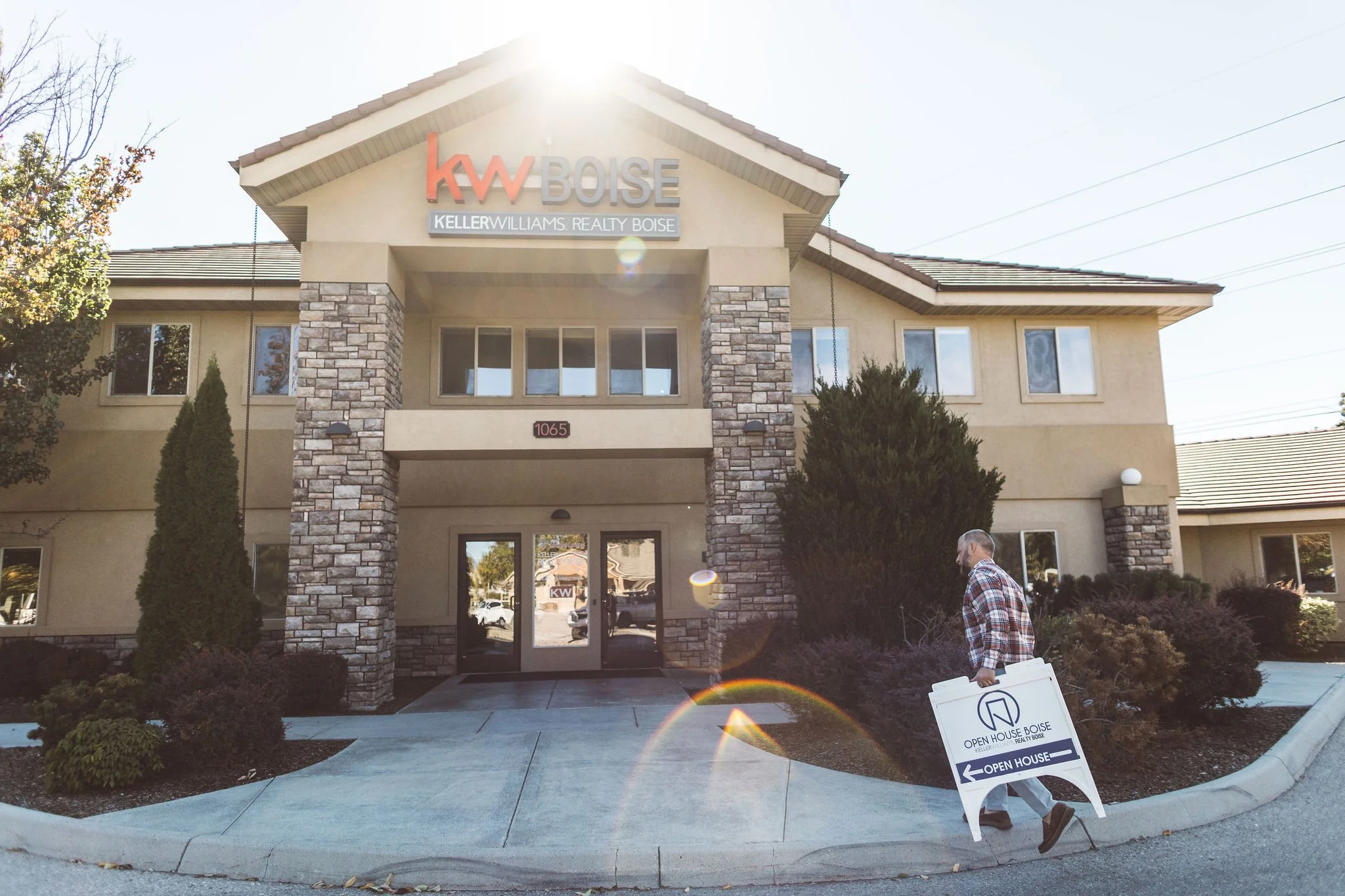 A person walking past an office building with a sign indicating an open house event.