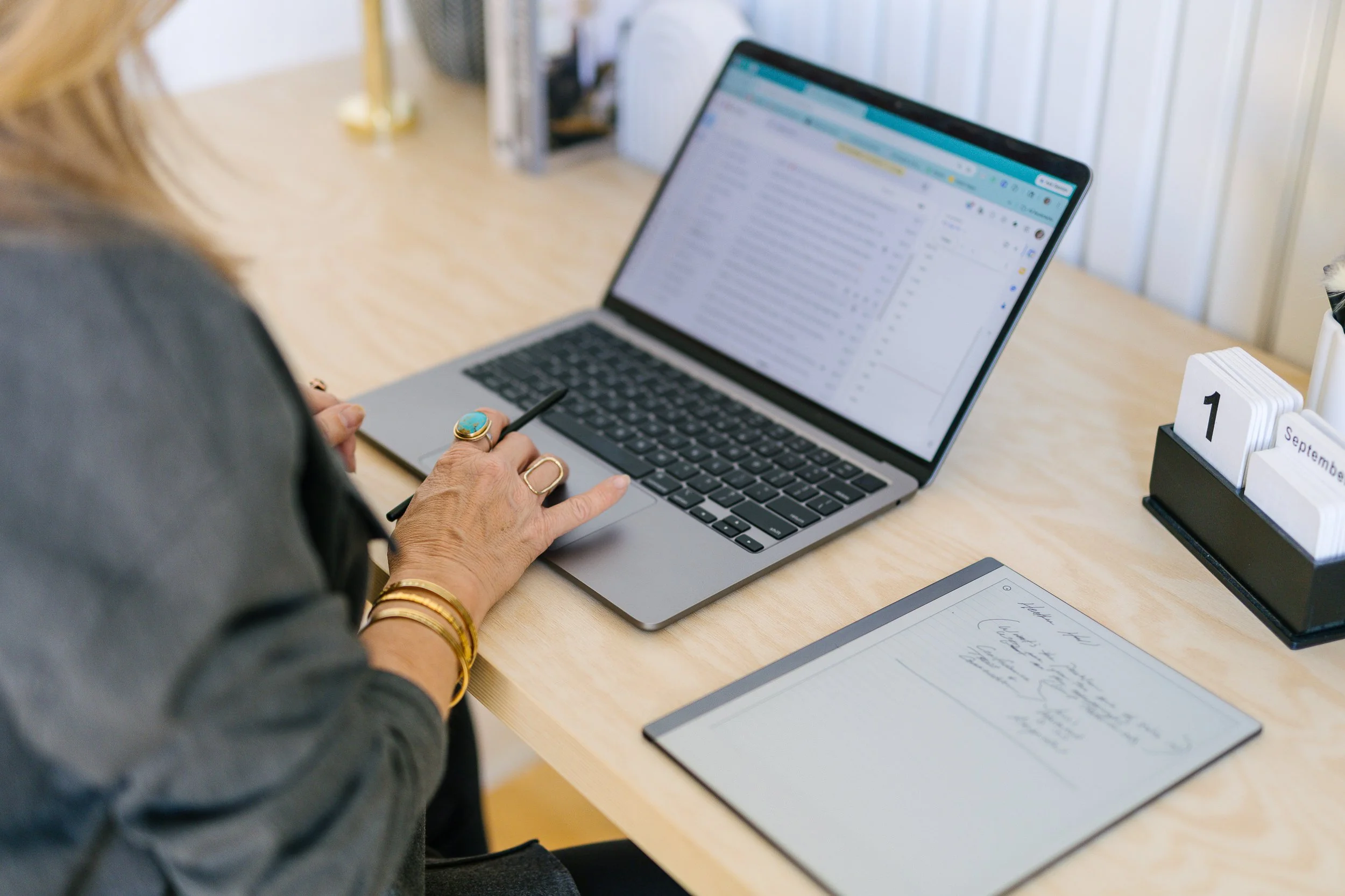 Woman business owner typing on a computer at a desk during a branding photoshoot in a studio in downtown Boise.