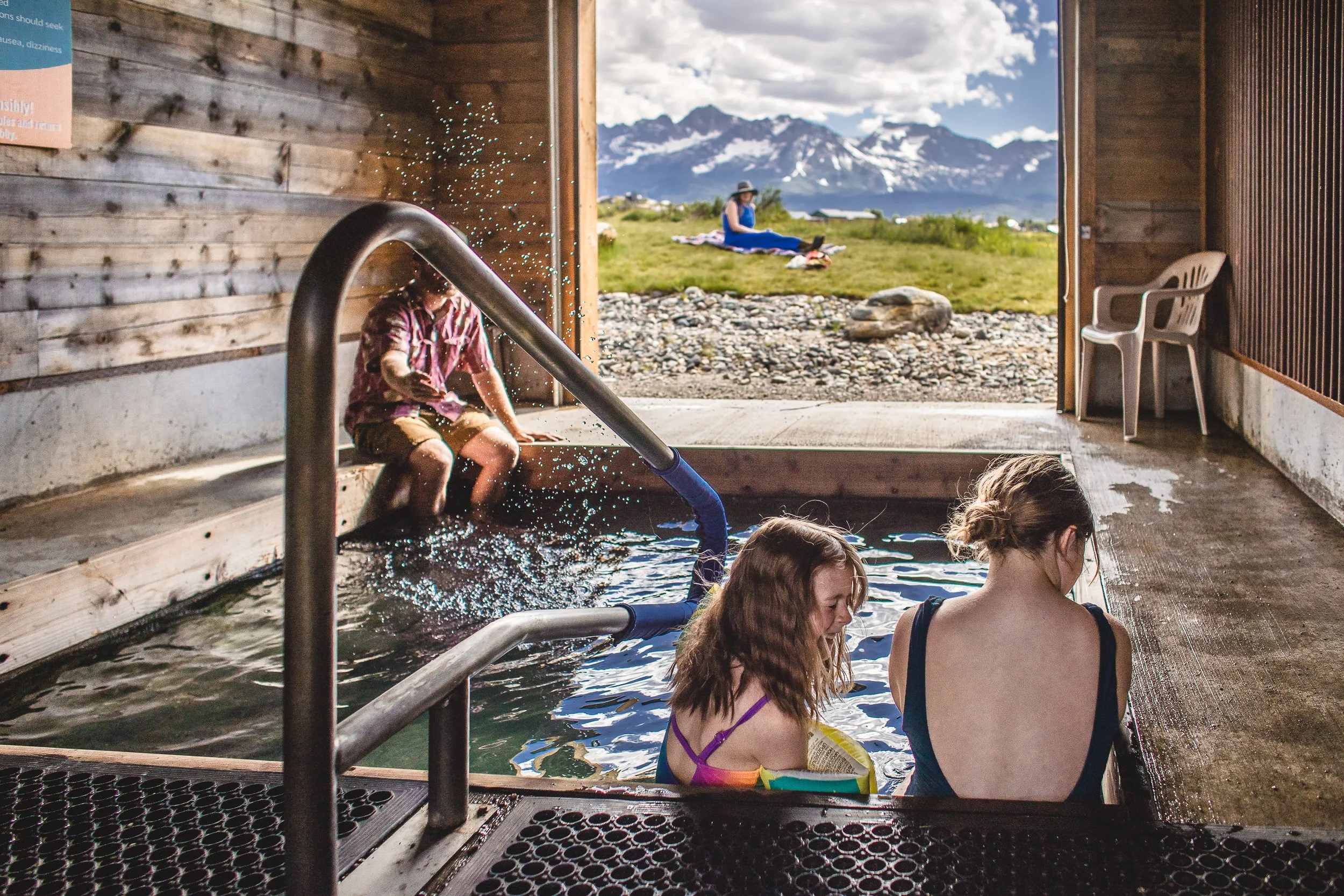 Family playing in a hot spring at Mountain Village Resort during a branding photoshoot in Stanley Idaho.