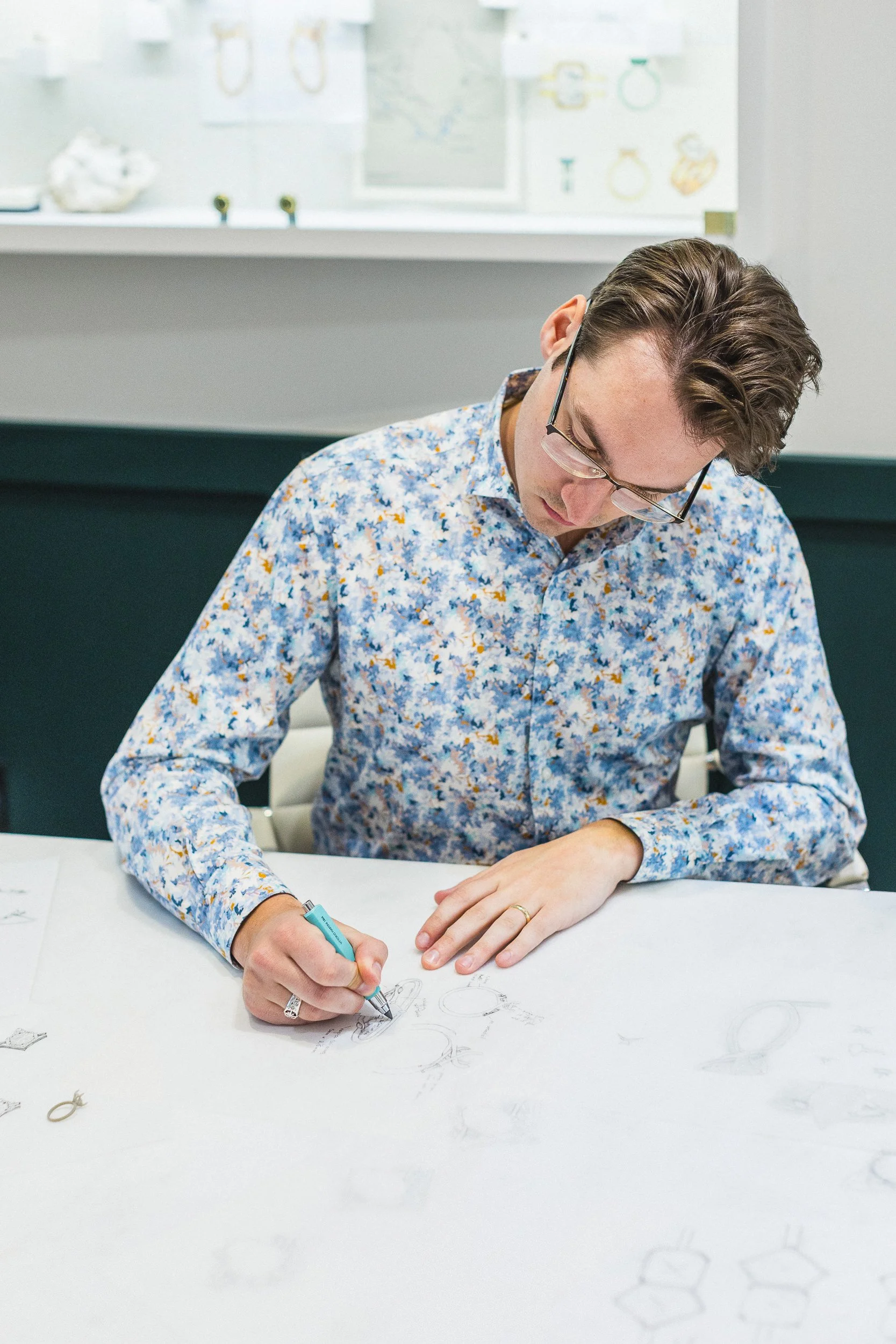Jewelry designer drawing a custom bracelet during a branding photoshoot in downtown Boise.