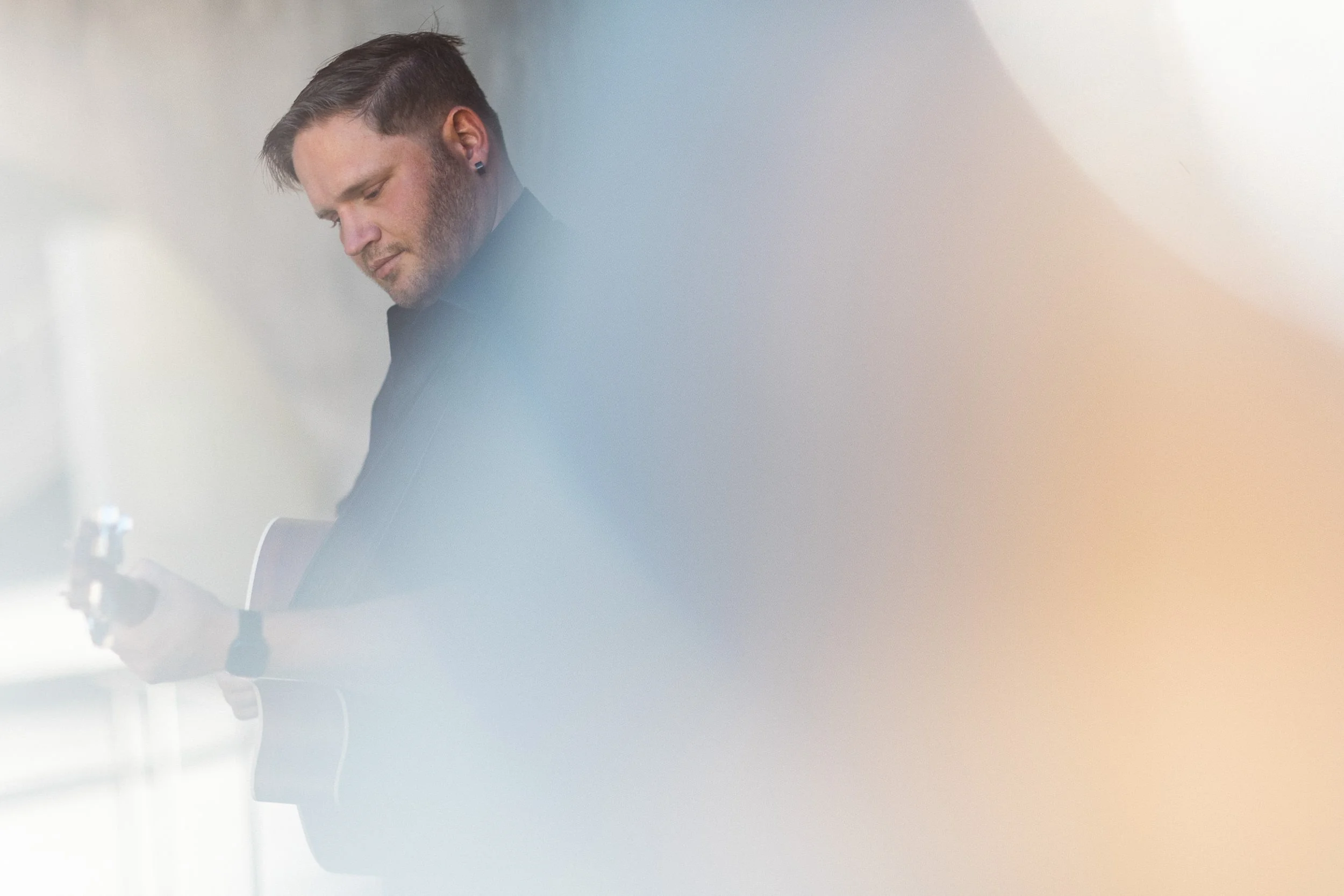 Musician playing guitar during a branding photoshoot at Jump in downtown Boise.