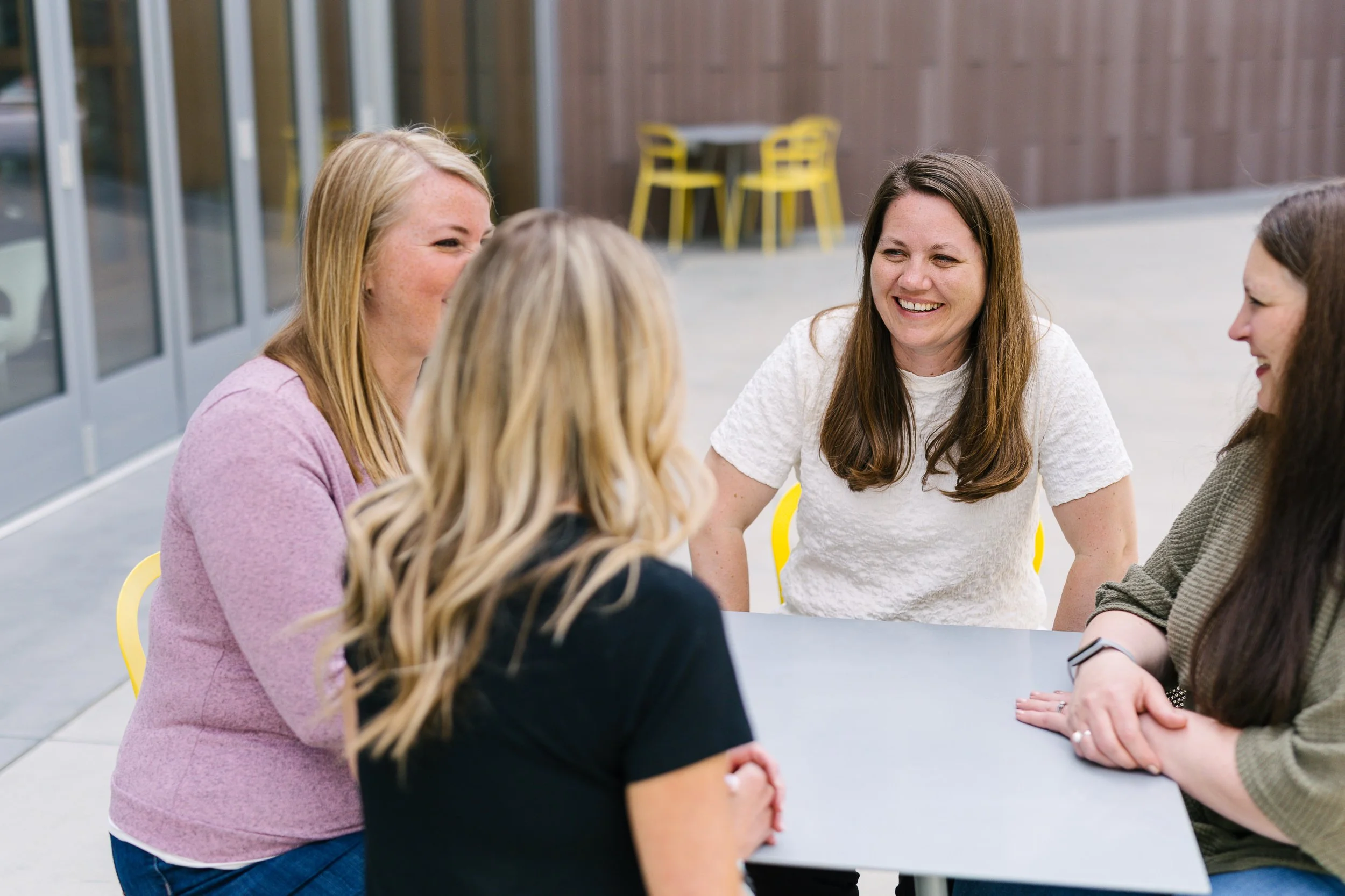 Group of employees from a small business smiling candidly at a table during a branding photoshoot in Boise.