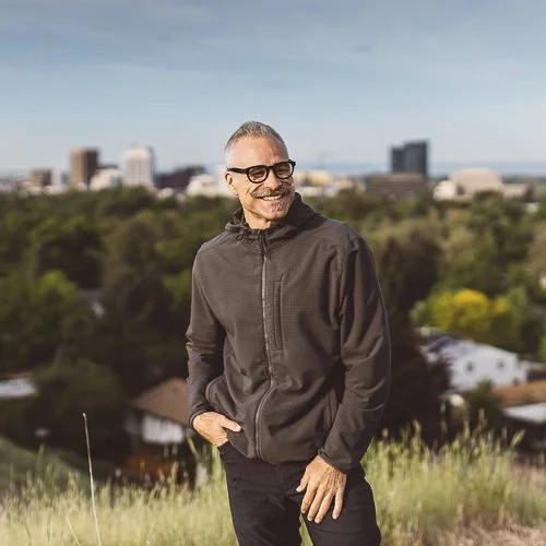 Outdoor branding photography session showing an entrepreneur photographed in the foothills in Boise, Idaho with downtown in the background.