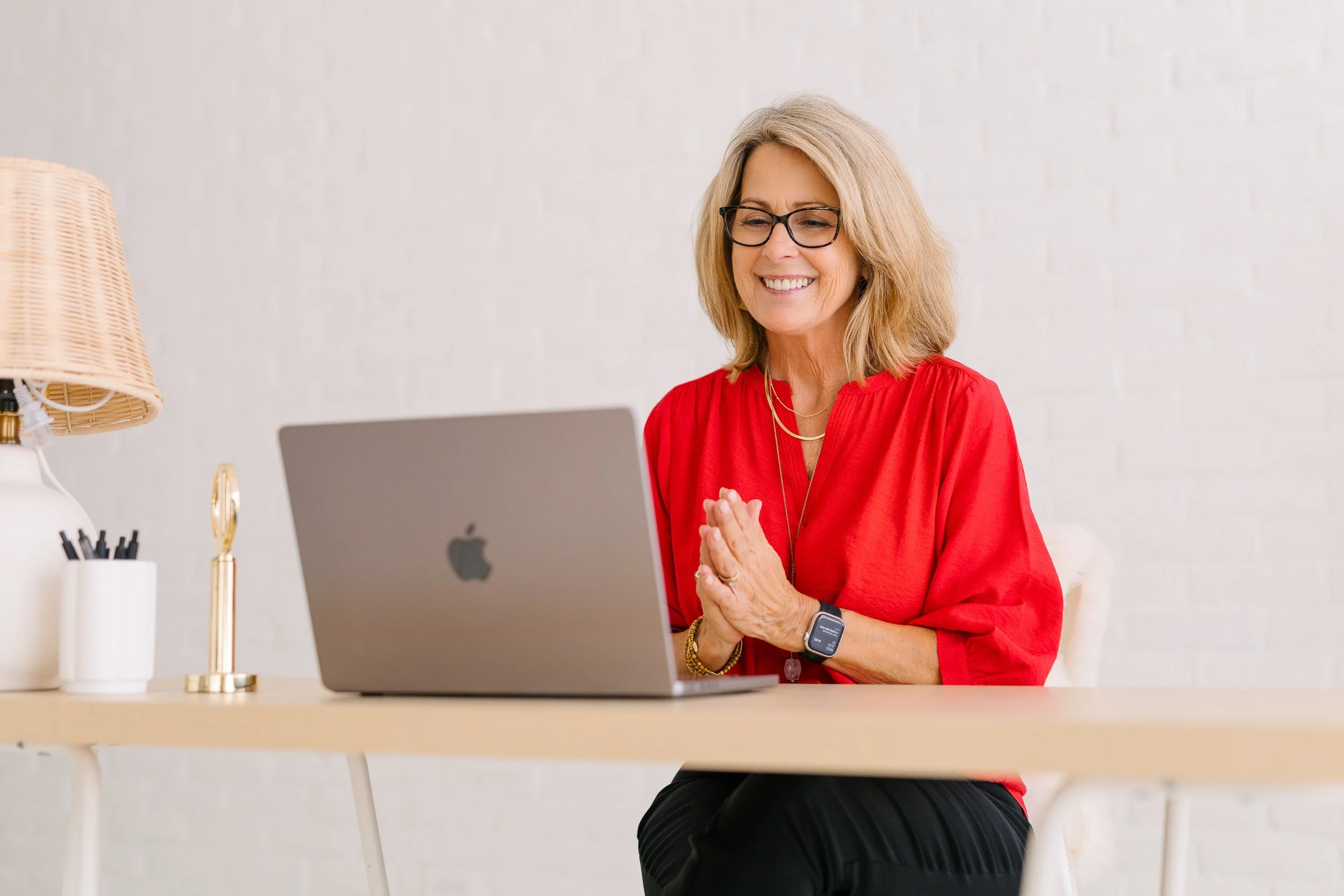 Woman business owner smiling at her computer while on a consulting call during a personal branding photography session in a studio in downtown Boise.