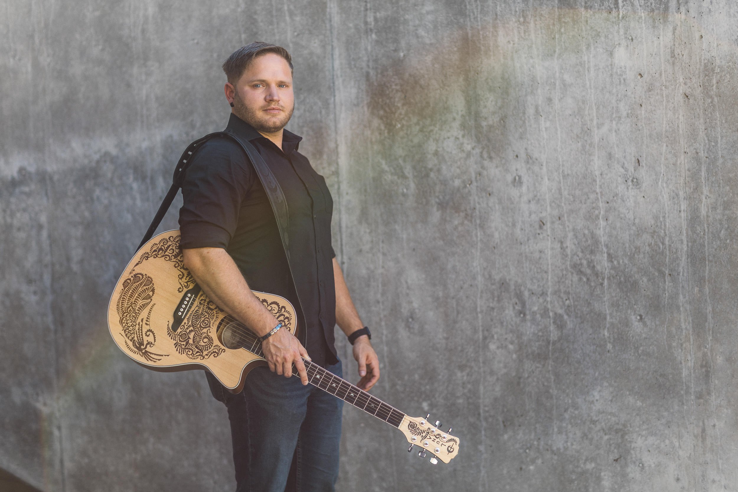 Creative entrepreneur holding a guitar during a branding photoshoot at Jump in downtown Boise.