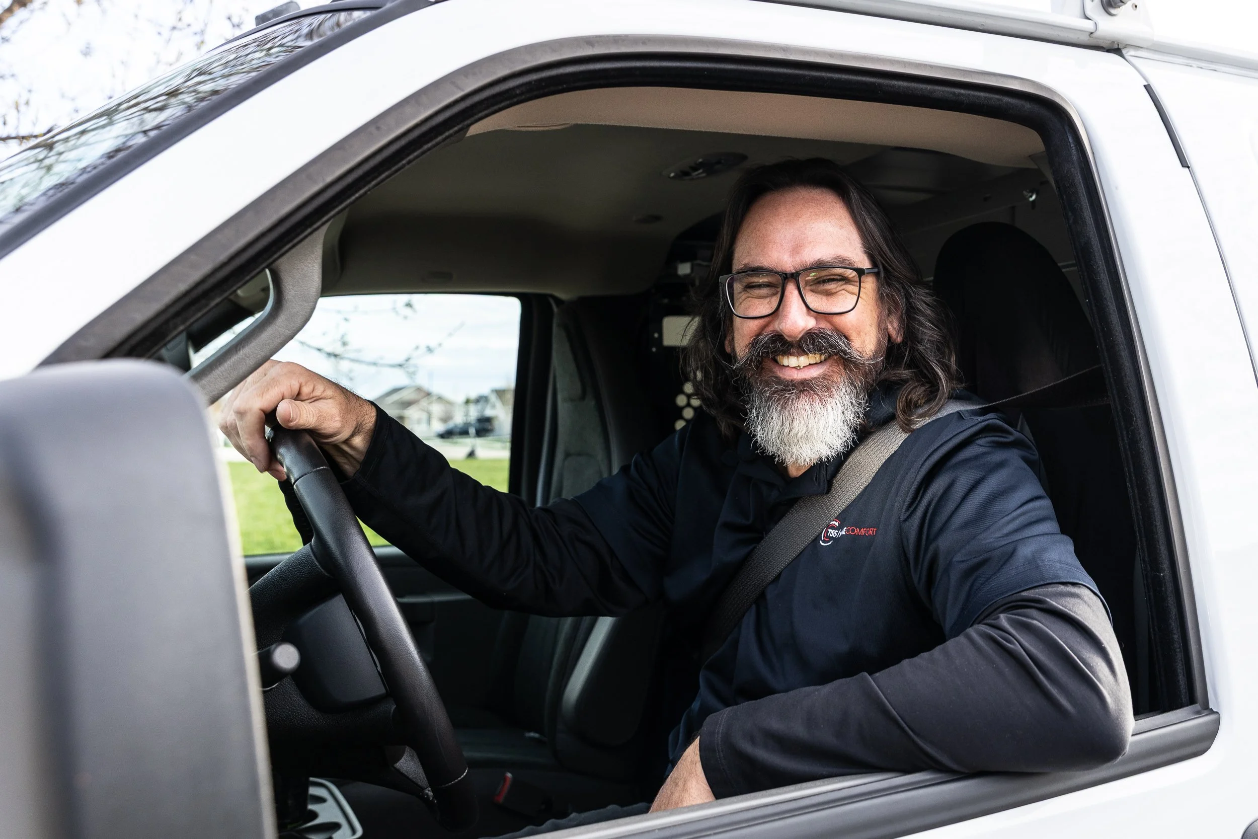 HVAC technician smiling in vehicle during a commercial photoshoot in Boise.