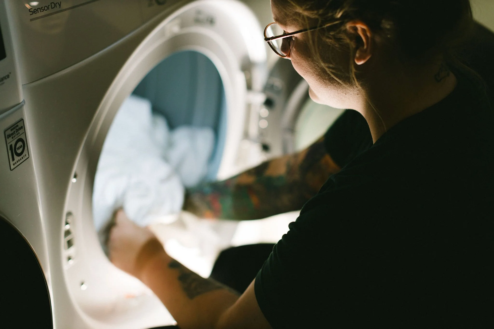 Branding photo of a woman doing laundry during a branding photoshoot in a private home in the north end in Boise, Idaho.