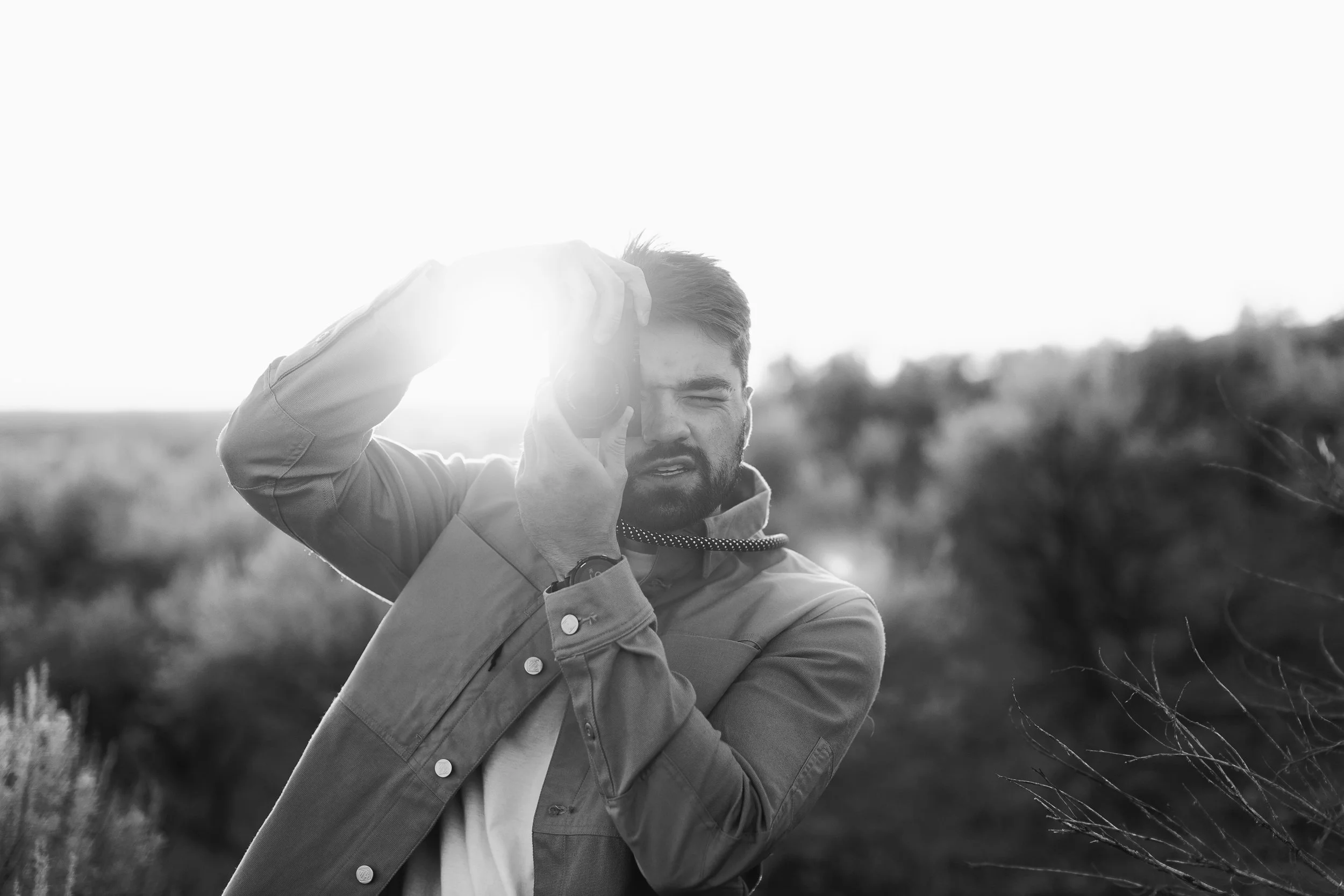 A small business owner takes a photo in the Boise foothills during a boise branding photography session at sunset.