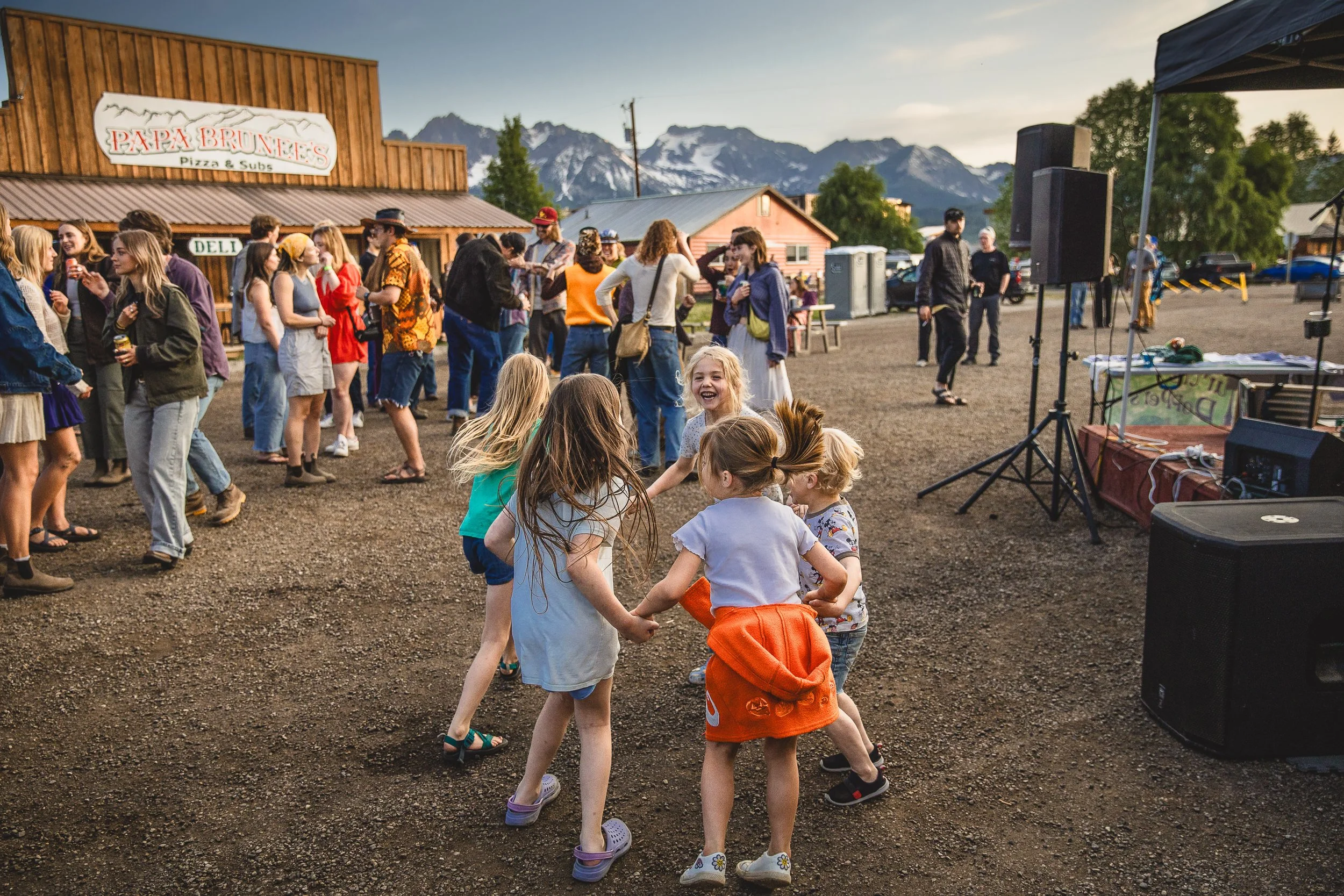Branding photography session of kids laughing and dancing at the Thursday night street dance in Stanley Idaho.