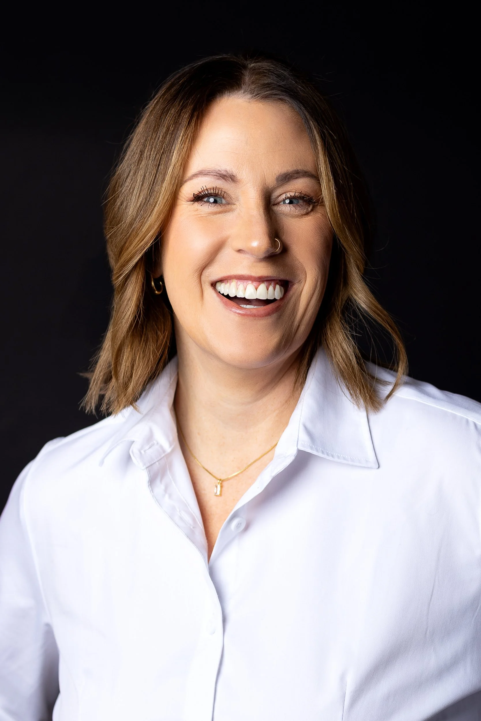 Marketing agency female chief operating officer photographed against a black background during a branding photo session in downtown Boise.