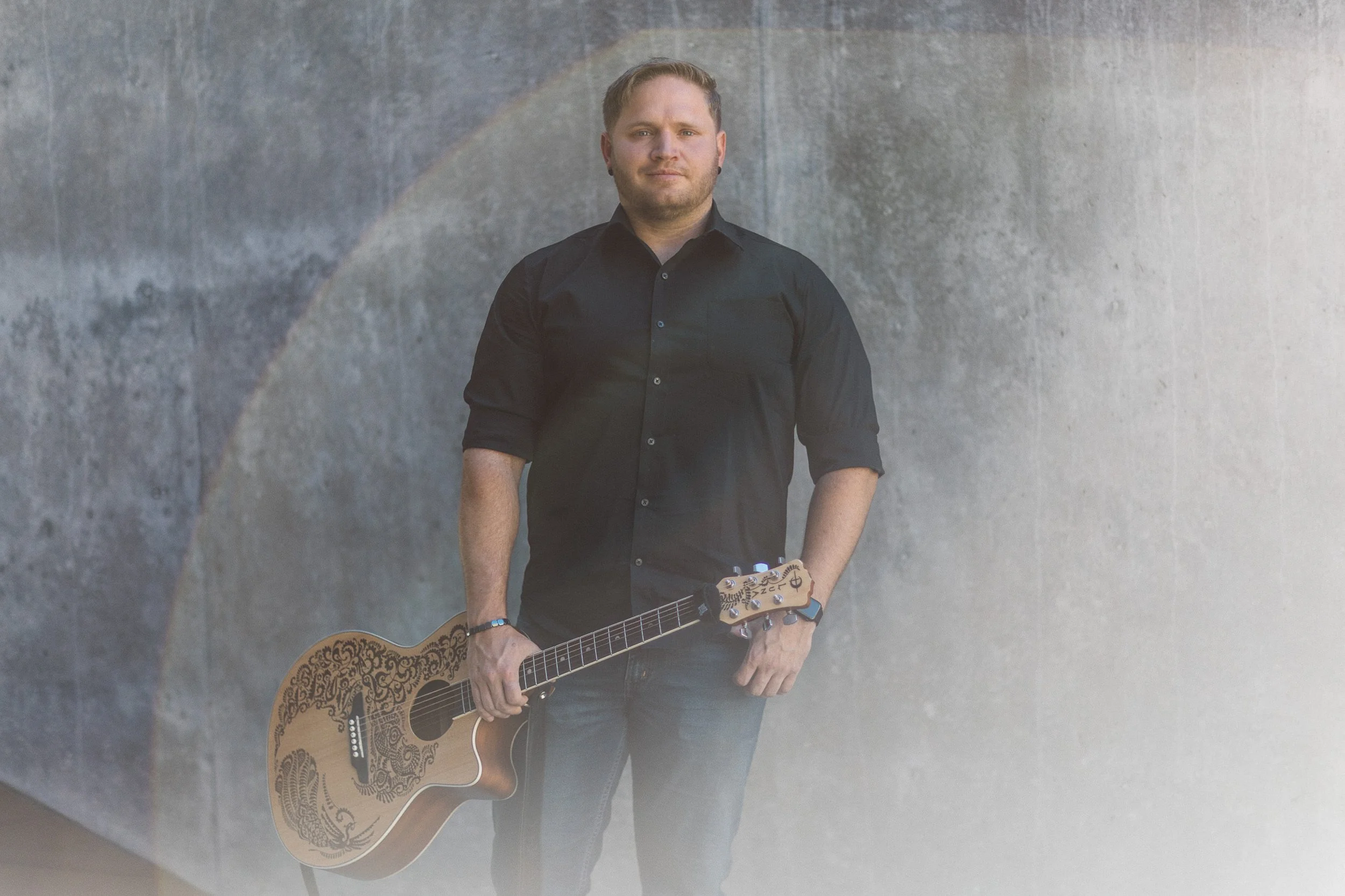 Boise branding photographer portrait of a musician looking at the camera at jump in downtown Boise during a branding photography session.