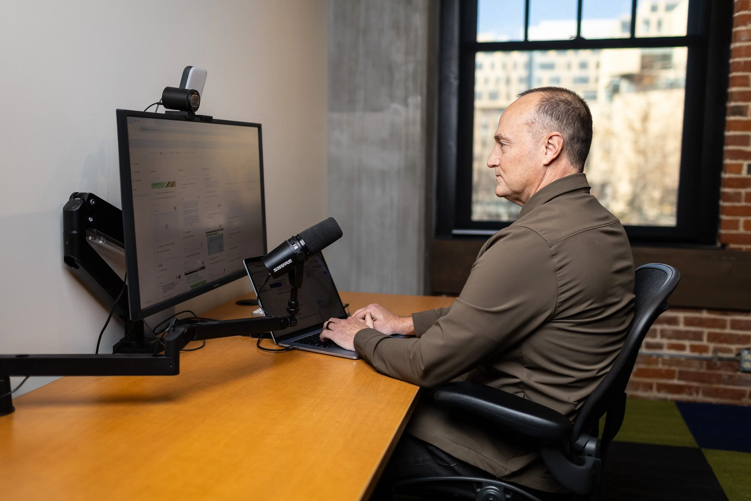 Director of client services for a marketing agency working at his desk during a branding photo session in Boise.