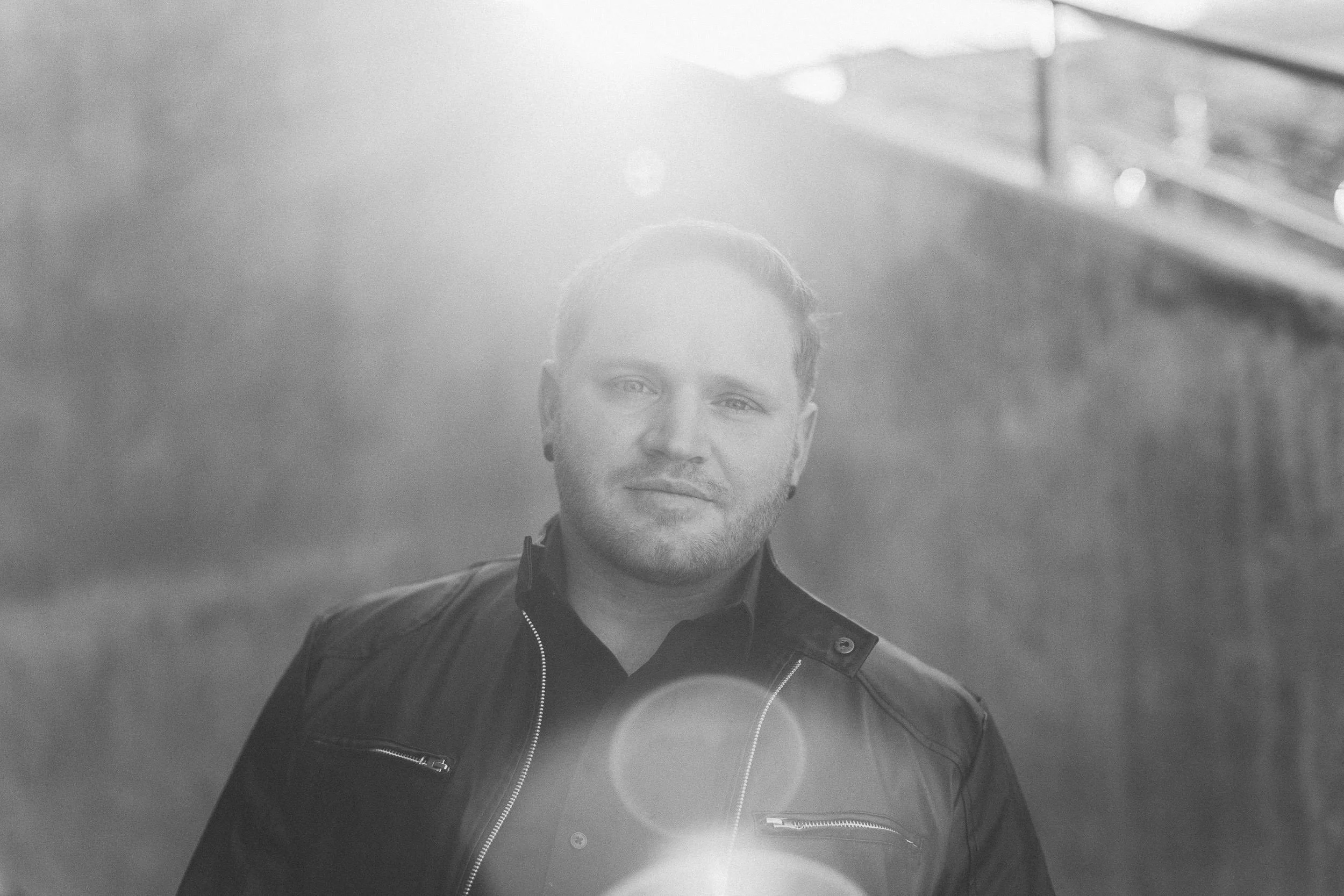 Male looking towards camera in leather jacket during a creative branding photography session in downtown Boise.