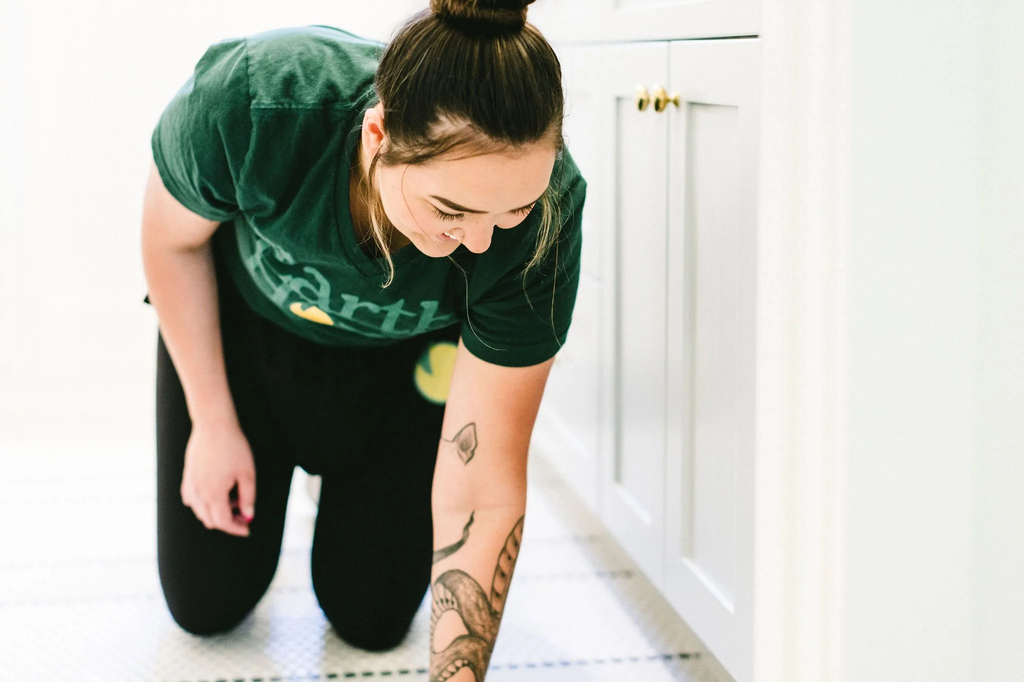 Branding photo of a woman business owner smiling candidly while cleaning a home during a branding photoshoot in Boise, Idaho.