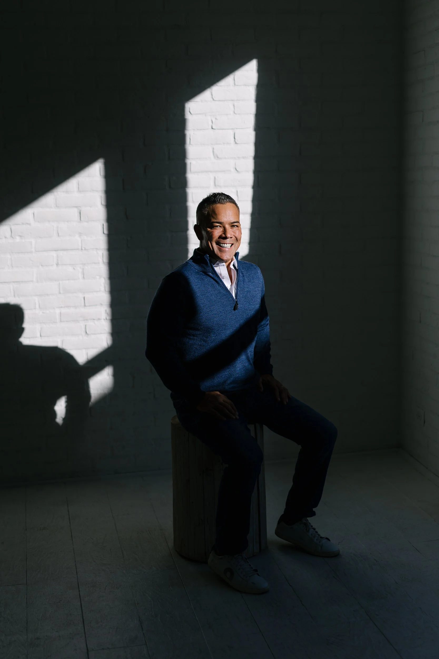 Mortgage broker Ryan Namba smiling in a natural light studio in downtown Boise during a branding photography session.