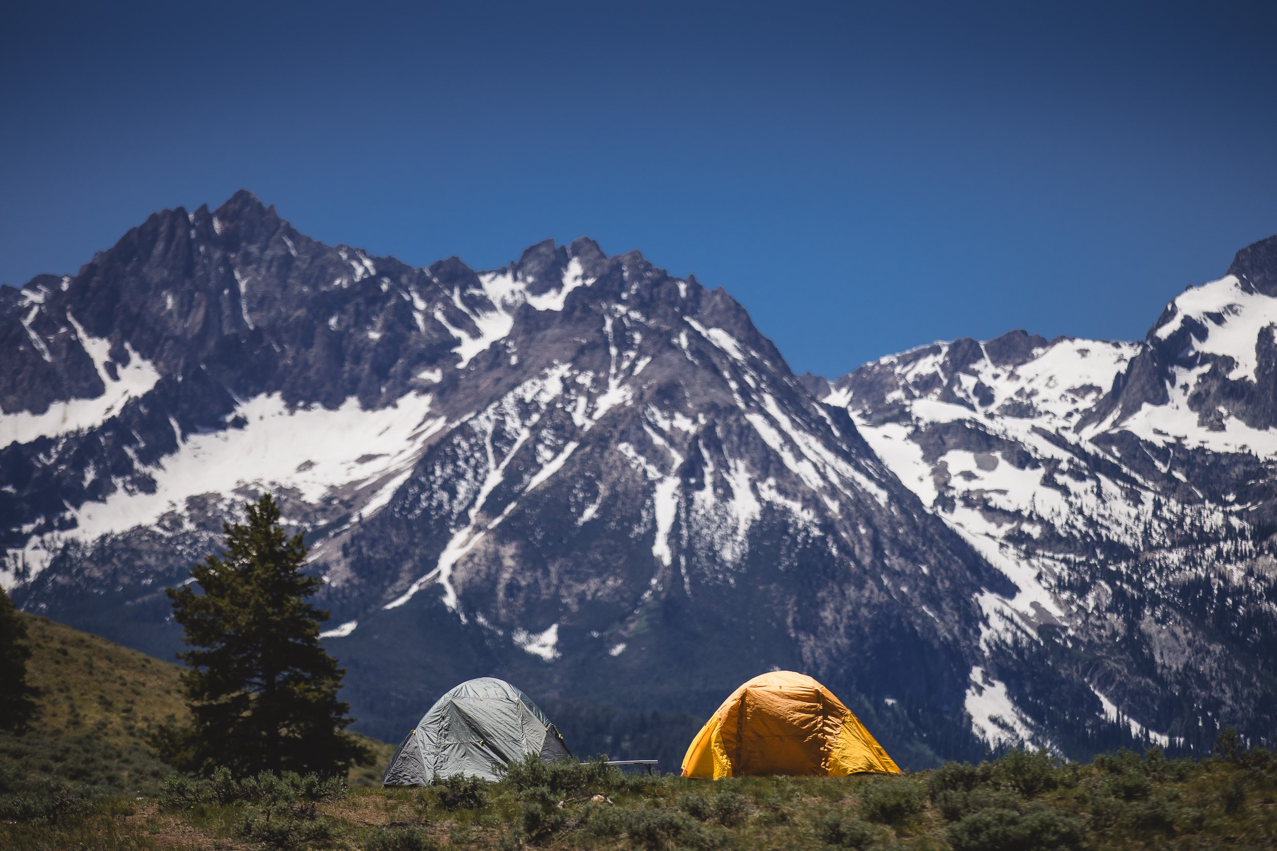 Two tents people are using for camping at the base of the Sawtooth Mountains during a branding photoshoot in Stanley Idaho.