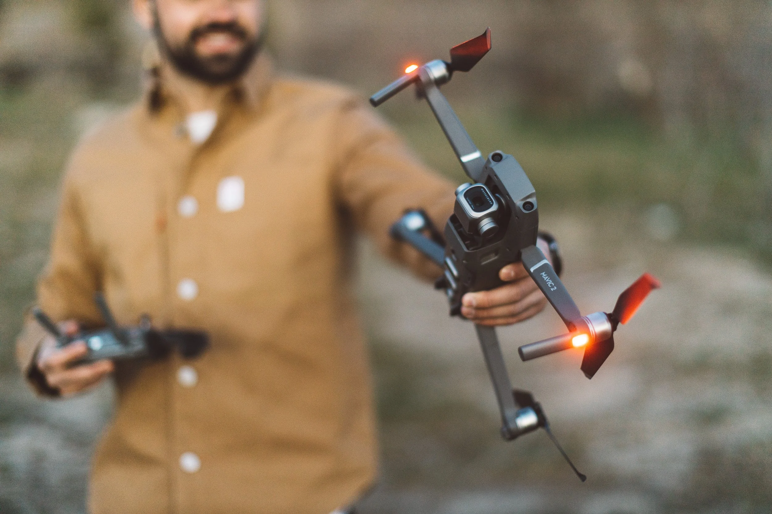 A media producer holds a drone in the Boise Foothills during a branding photoshoot.