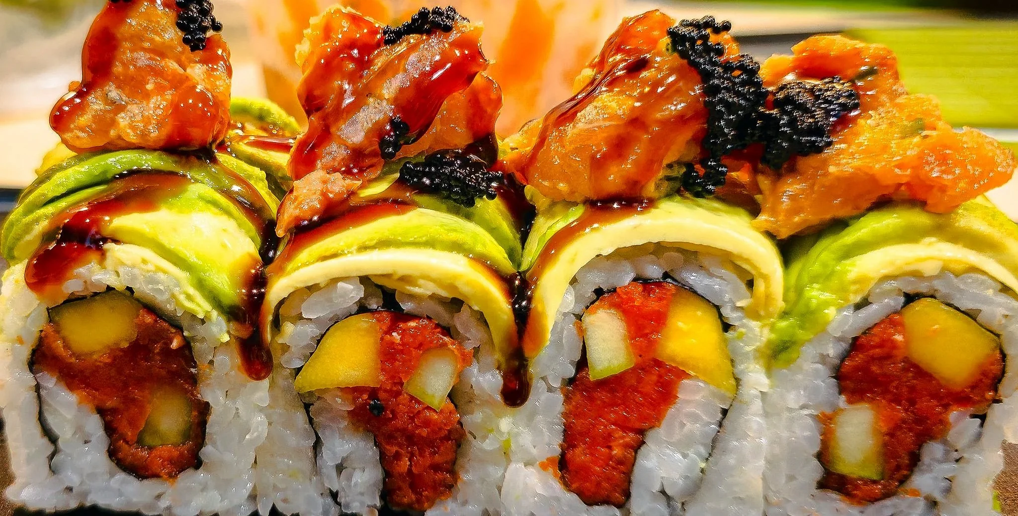 A vibrant food photography image featuring colorful sushi rolls with rich texture, sauce, and fresh ingredients. This close-up captures the detail and energy of restaurant-style presentation, making it useful for food prints, restaurant branding, soc